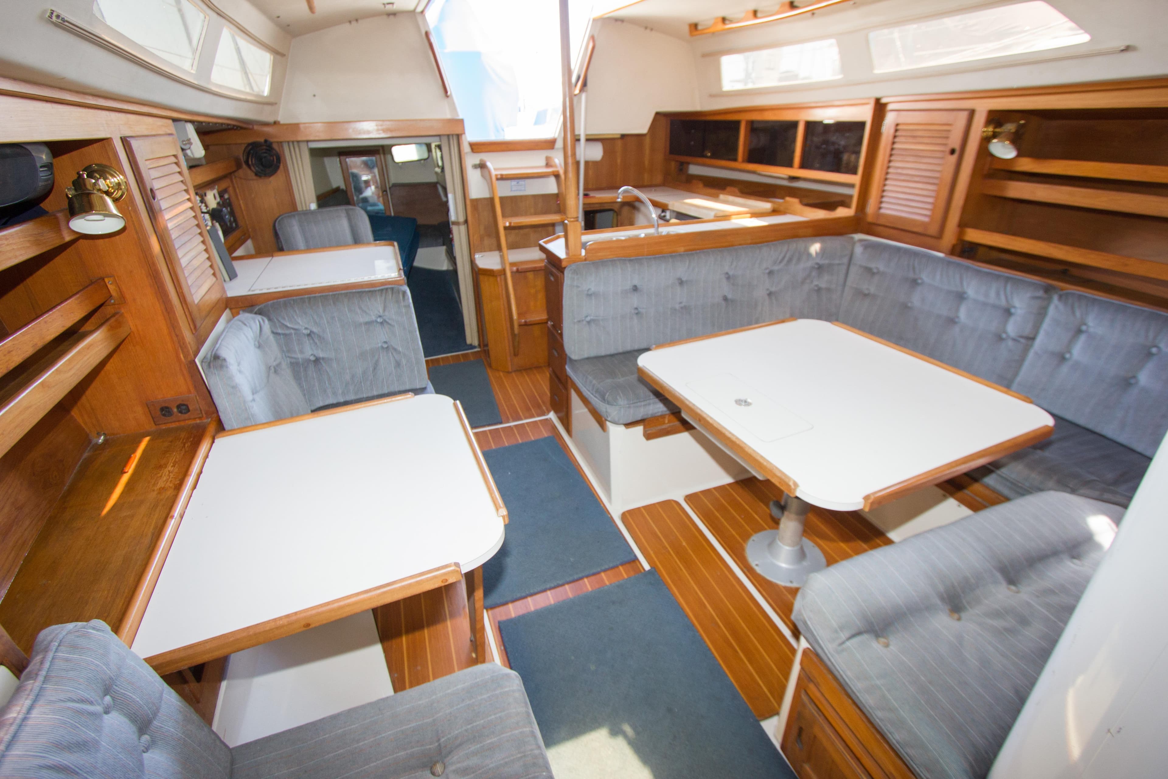 Interior of a 1991 Catalina 36 sailboat with cozy seating and wooden accents.