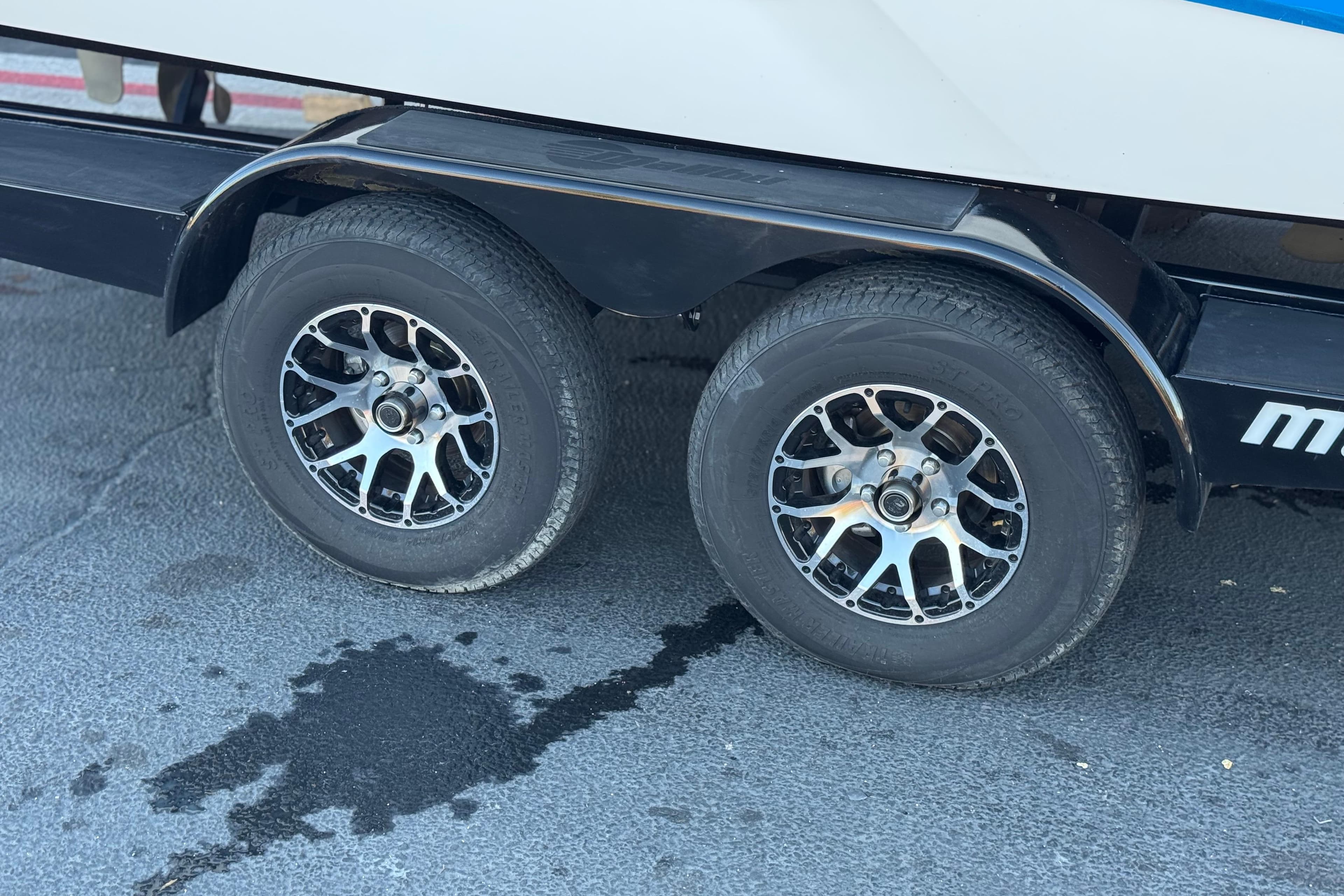 Trailer wheels of 2023 Malibu Wakesetter 21 LX on pavement.