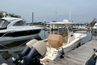 2018 Scout 255 LXF boat docked at marina with twin outboard engines.