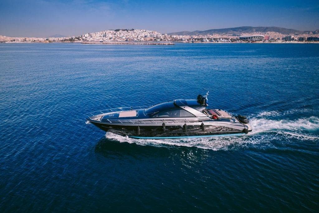 2006 Riva 68 Ego yacht cruising on blue ocean near coastal cityscape.