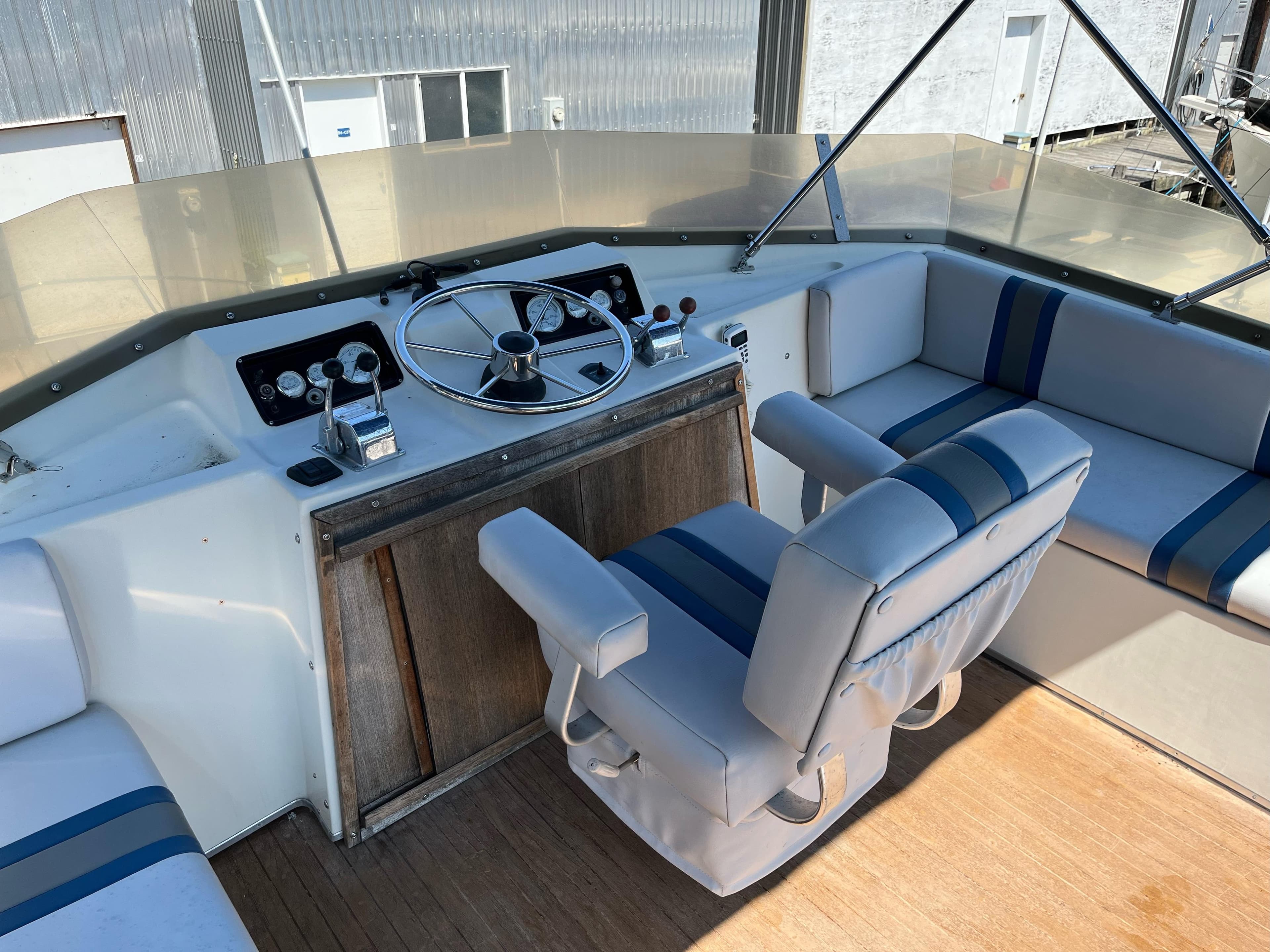 1976 Fiberform Executive 3300 boat cockpit with steering wheel and cushioned seating.