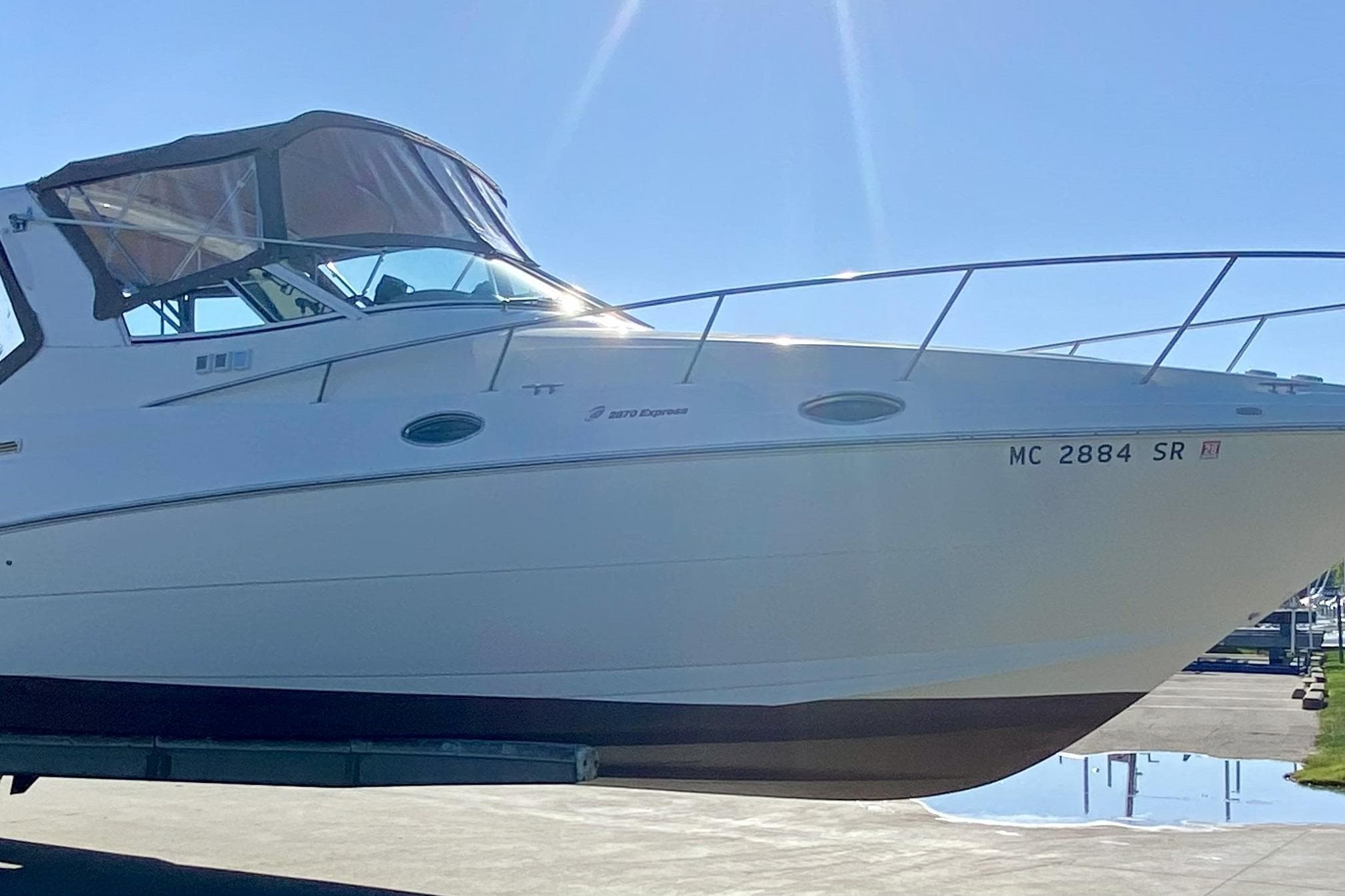 2003 Cruisers Yachts 2870 Express boat on trailer under clear blue sky.