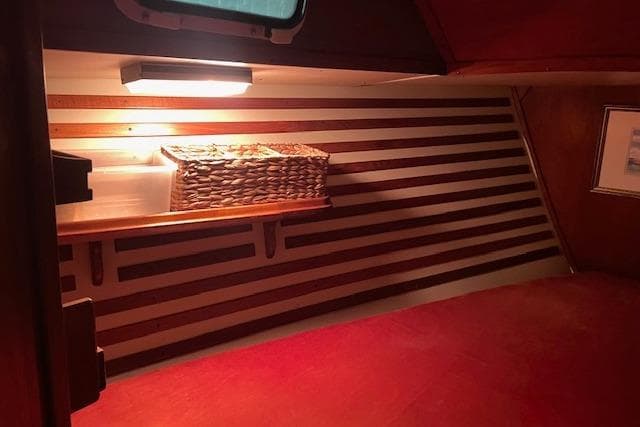 Cozy interior of 1984 Endeavour 35 sailboat with wooden accents and wicker basket.