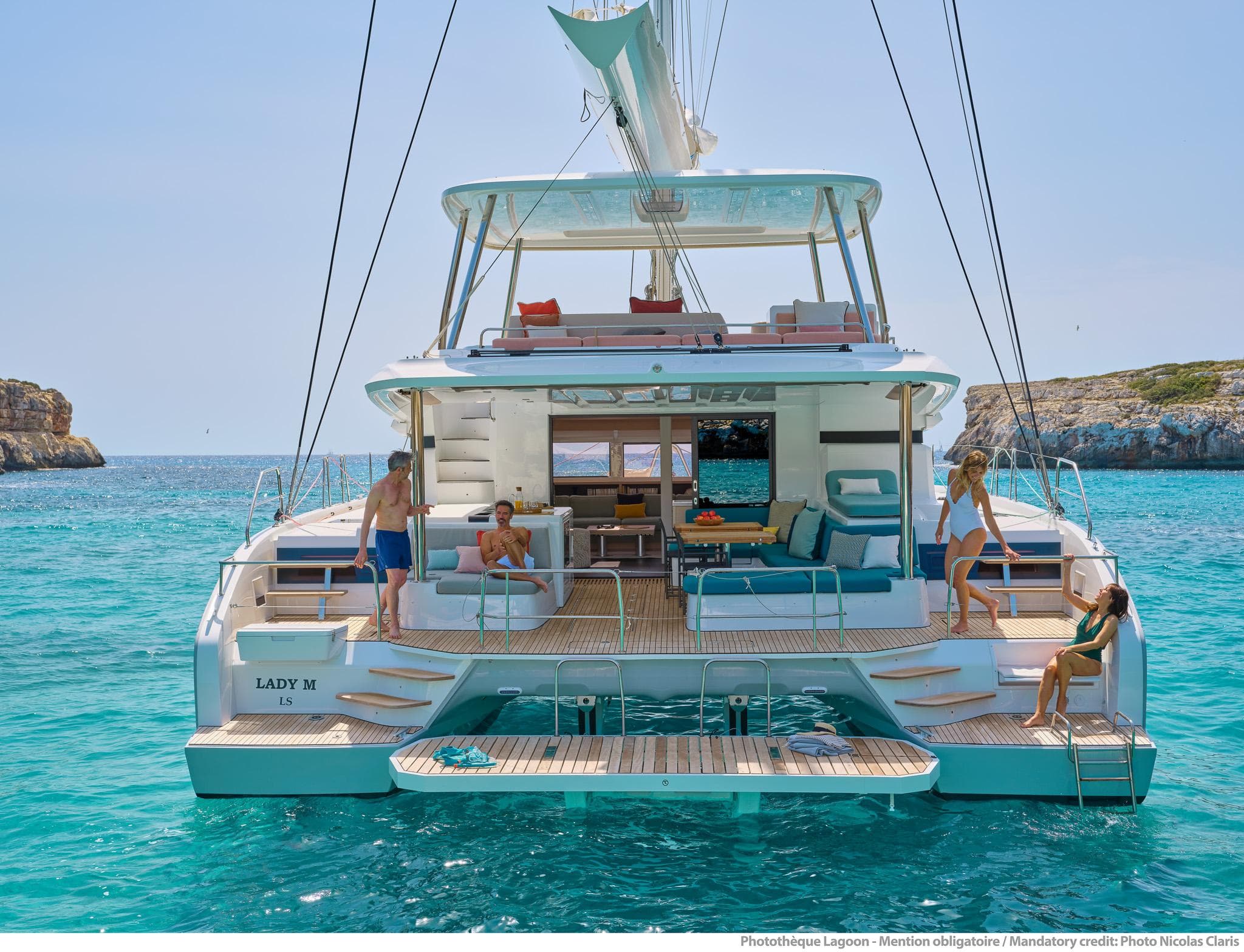 2025 Lagoon 55 yacht on turquoise water, featuring spacious deck and lounging area.
