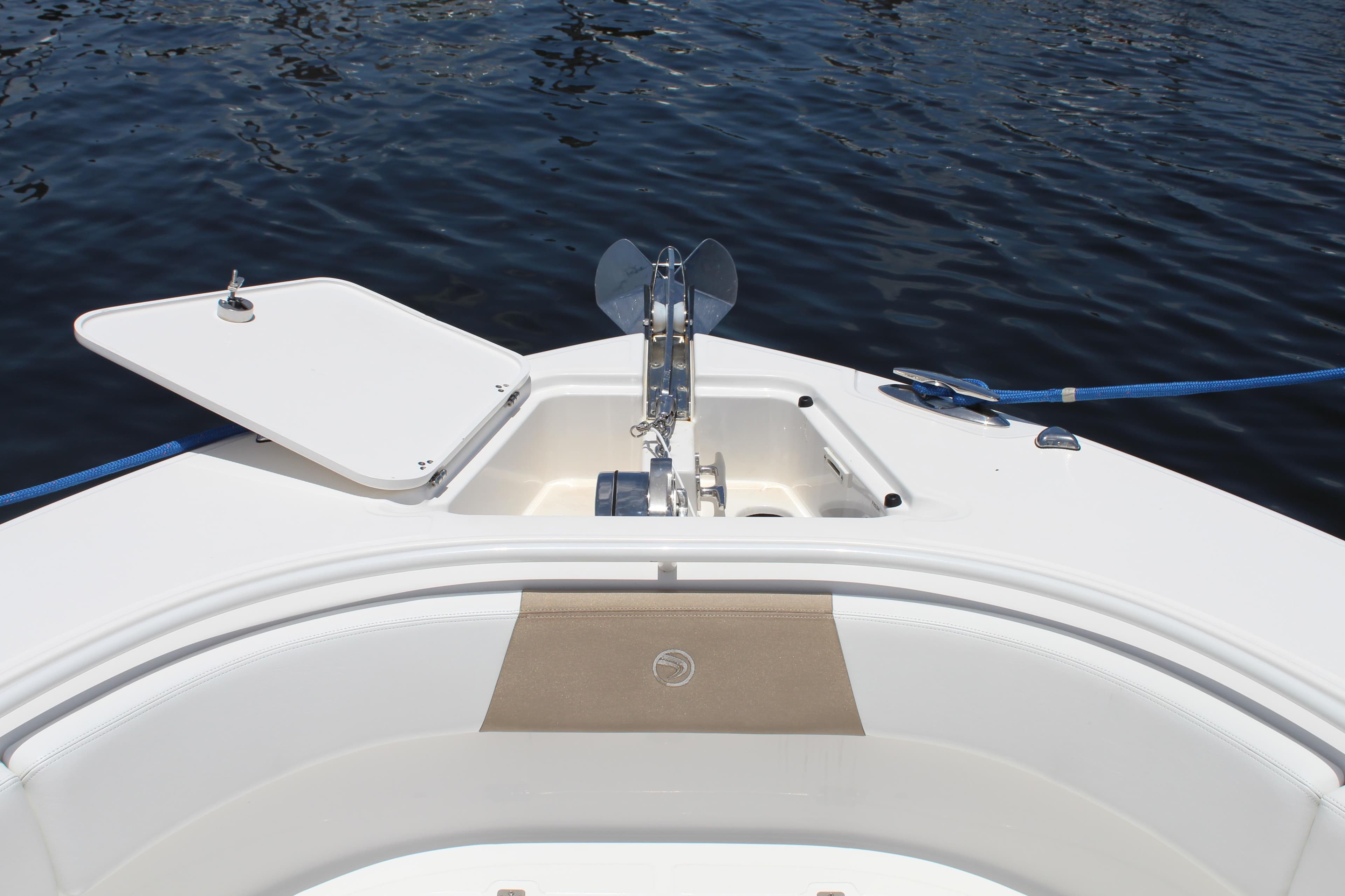 Bow of 2016 Edgewater 370CC boat with anchor and open hatch on calm water.