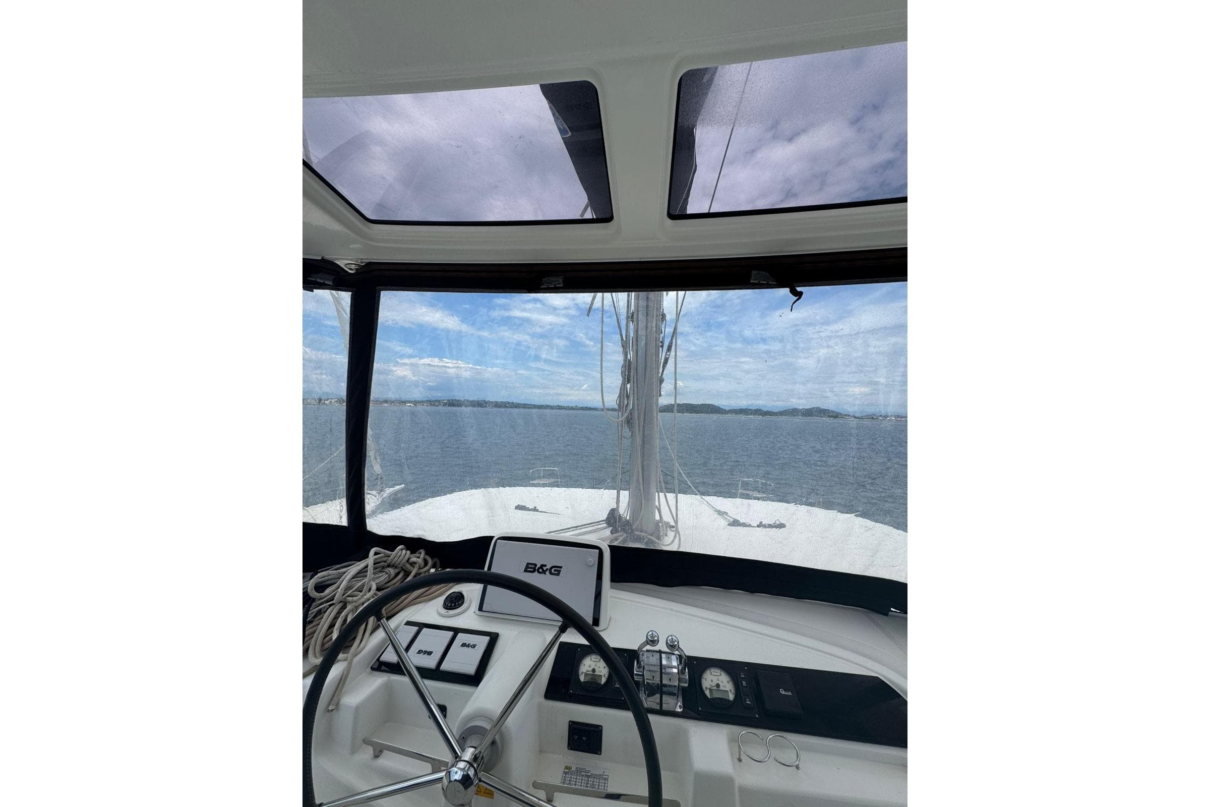 Helm view of 2021 Lagoon 46 catamaran sailing on open water.
