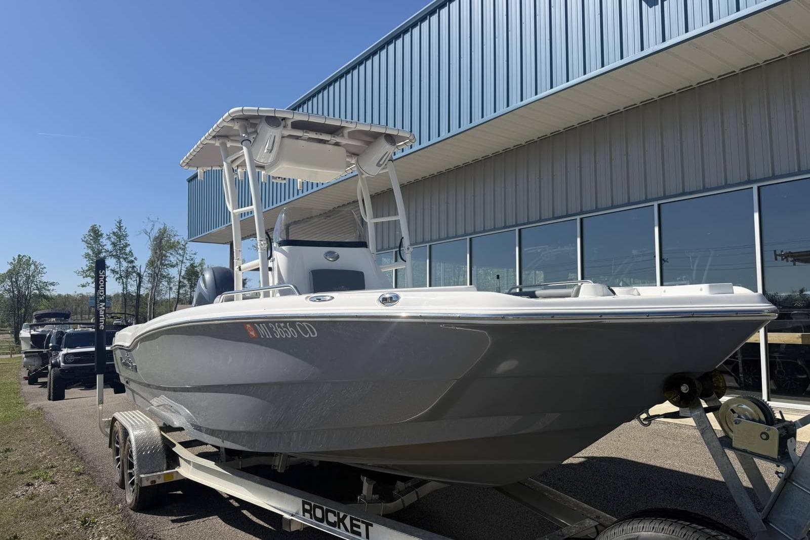 2023 NauticStar 211 Hybrid boat on trailer outside a building.