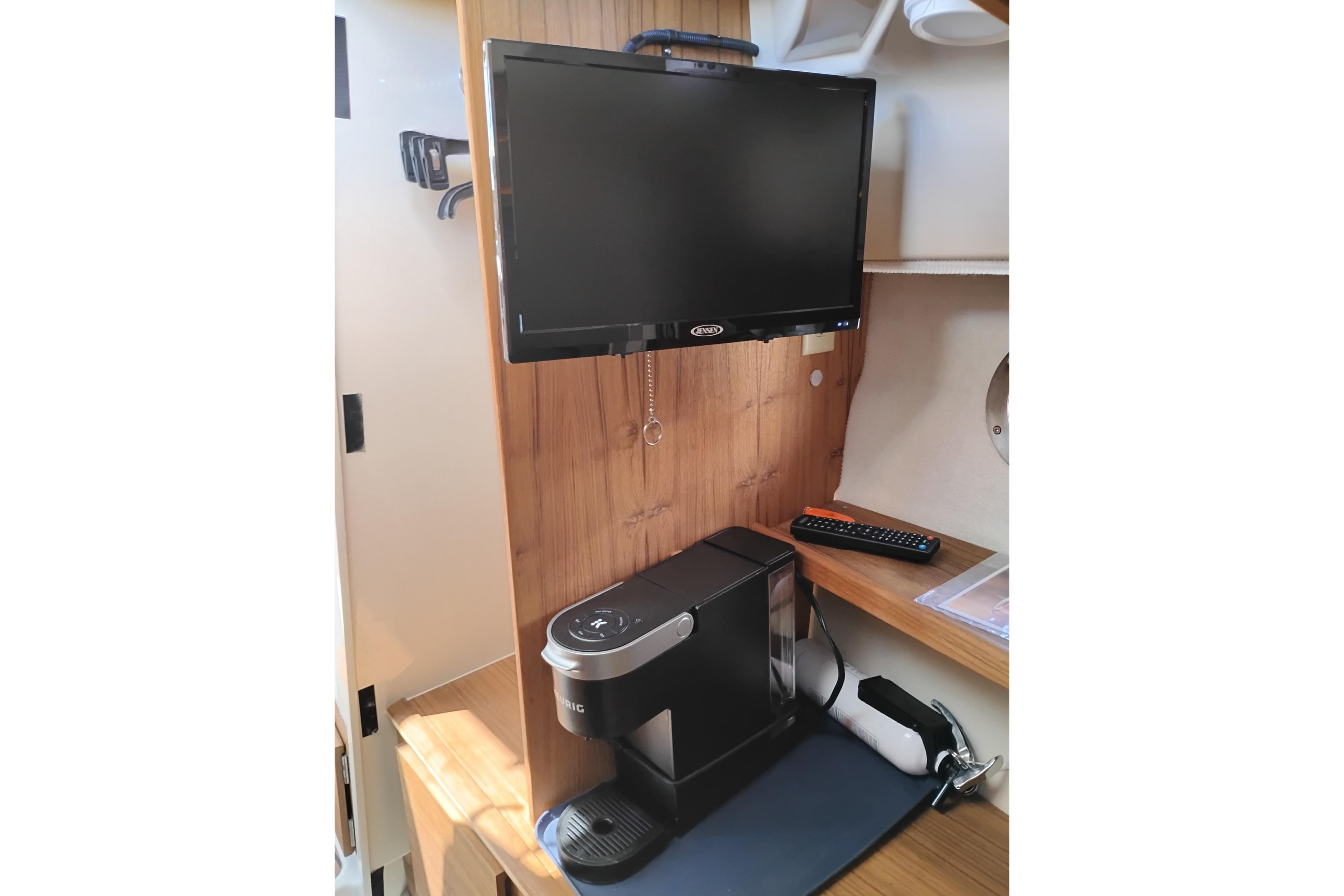 2024 Ranger Tugs R-27 interior with TV and coffee maker setup.