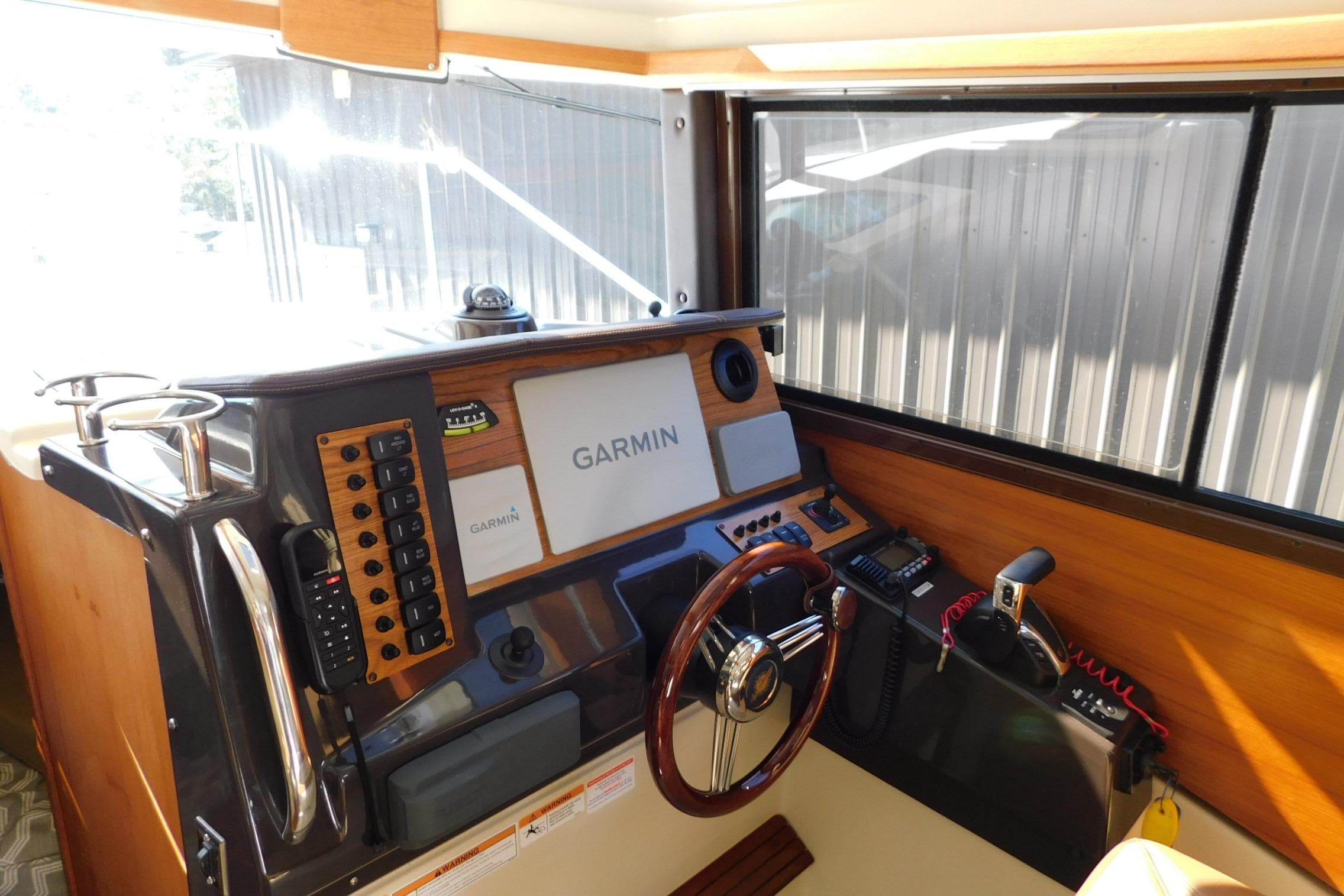 2022 Ranger Tugs R-27 helm with Garmin navigation system and wooden steering wheel.