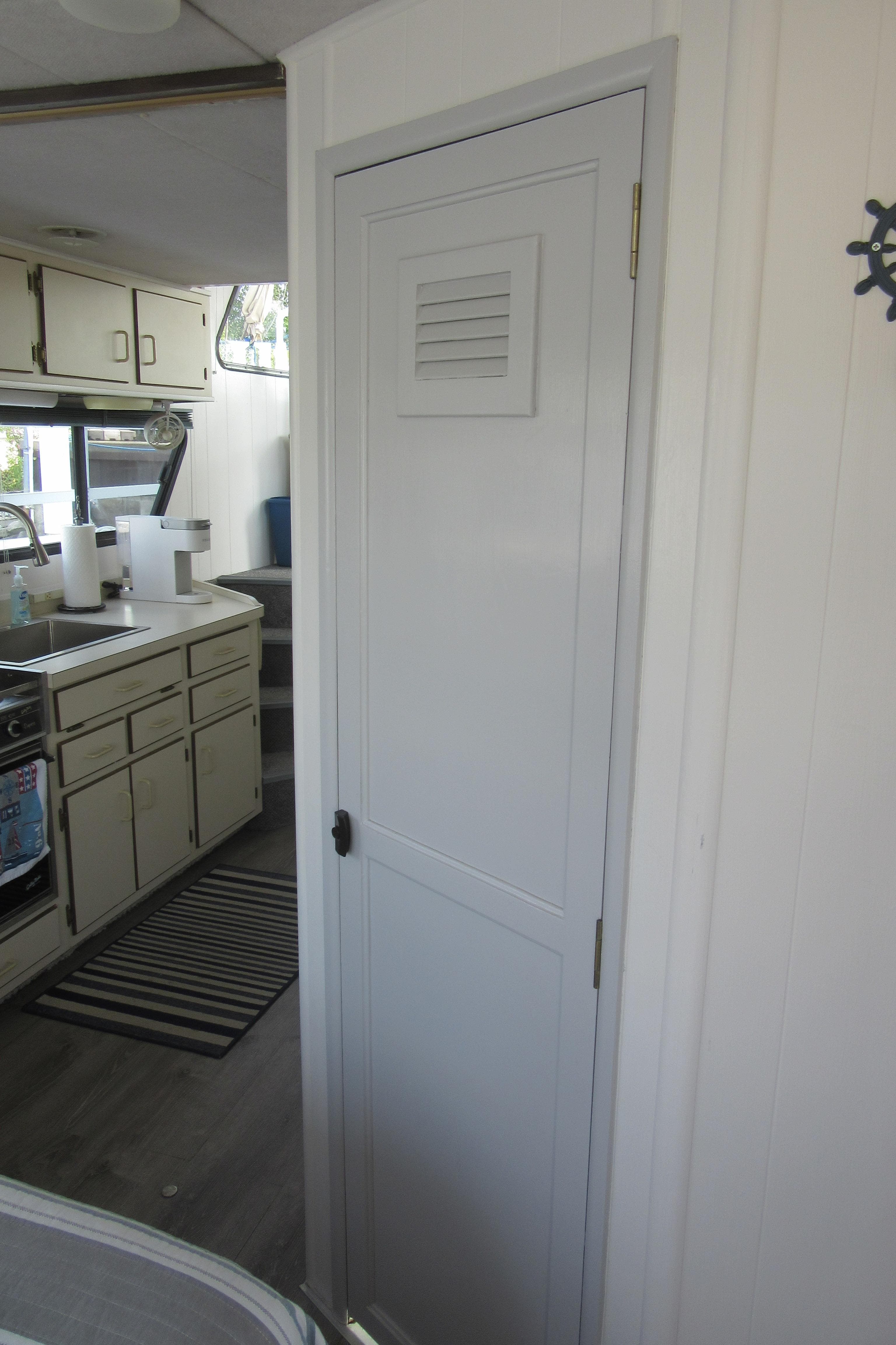 Interior of 1995 Gibson 44 Classic boat with kitchen and white door.
