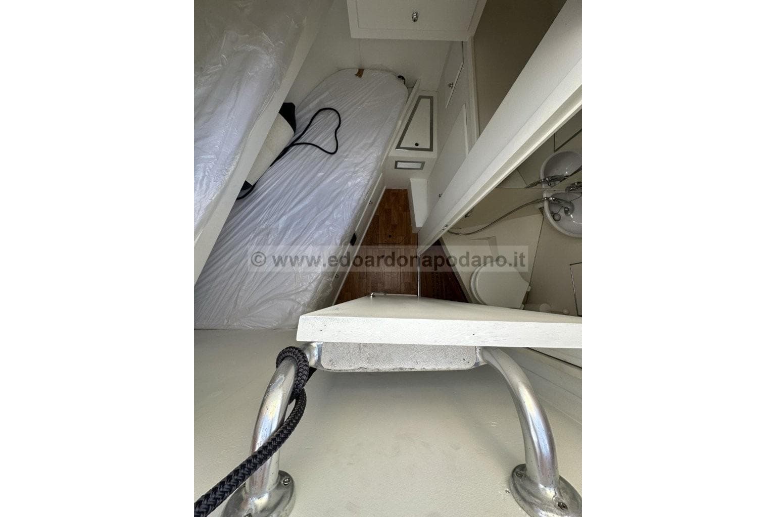 1973 Cantieri di Pisa Atlas yacht interior with bed, sink, and storage.