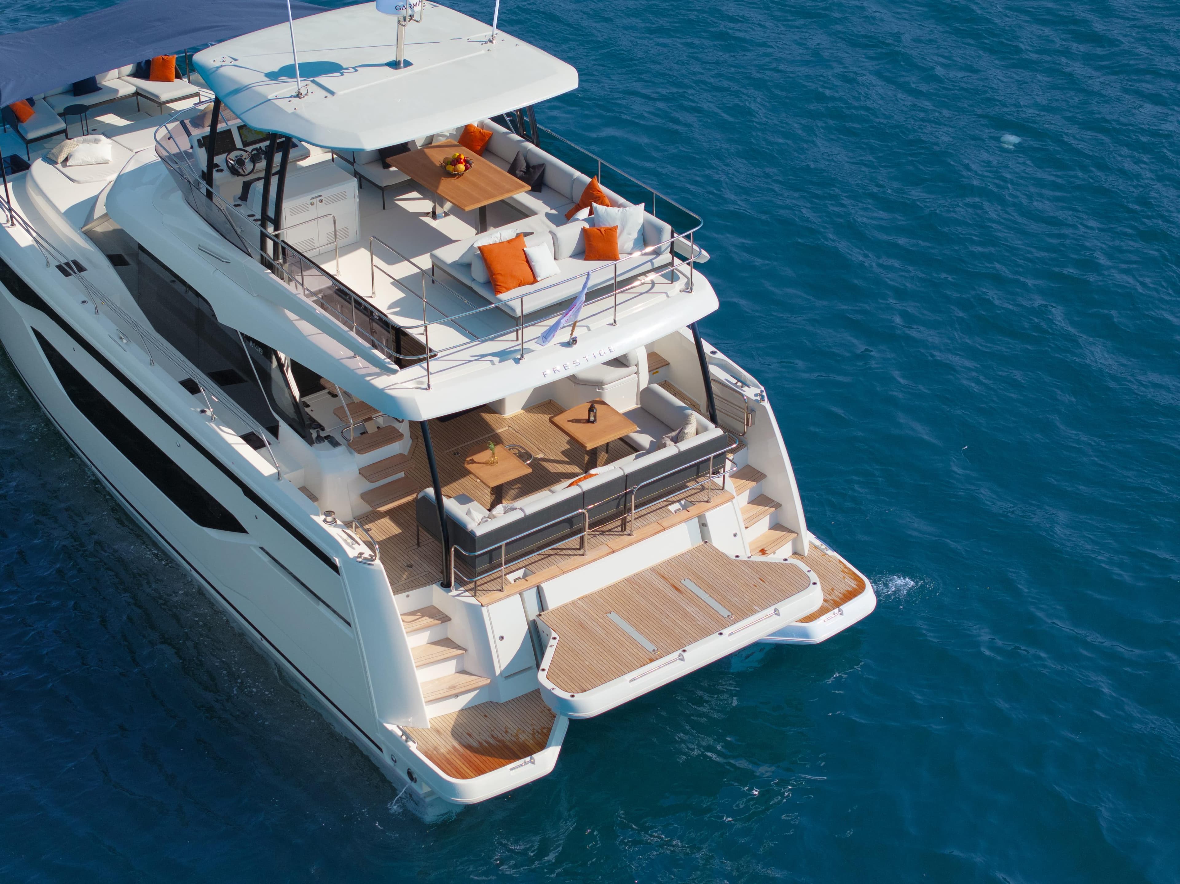 Luxurious 2025 Prestige M48 yacht on blue ocean, featuring spacious decks and elegant seating.