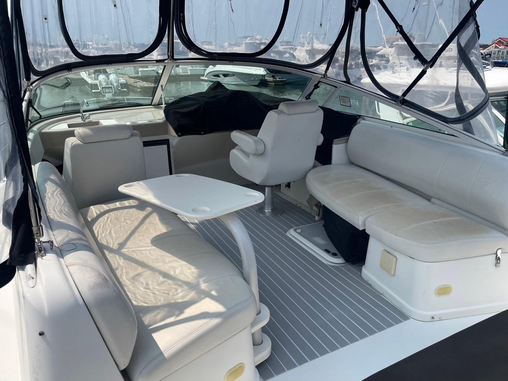 2006 Carver 36 Mariner yacht interior with white seating and table, docked at marina.