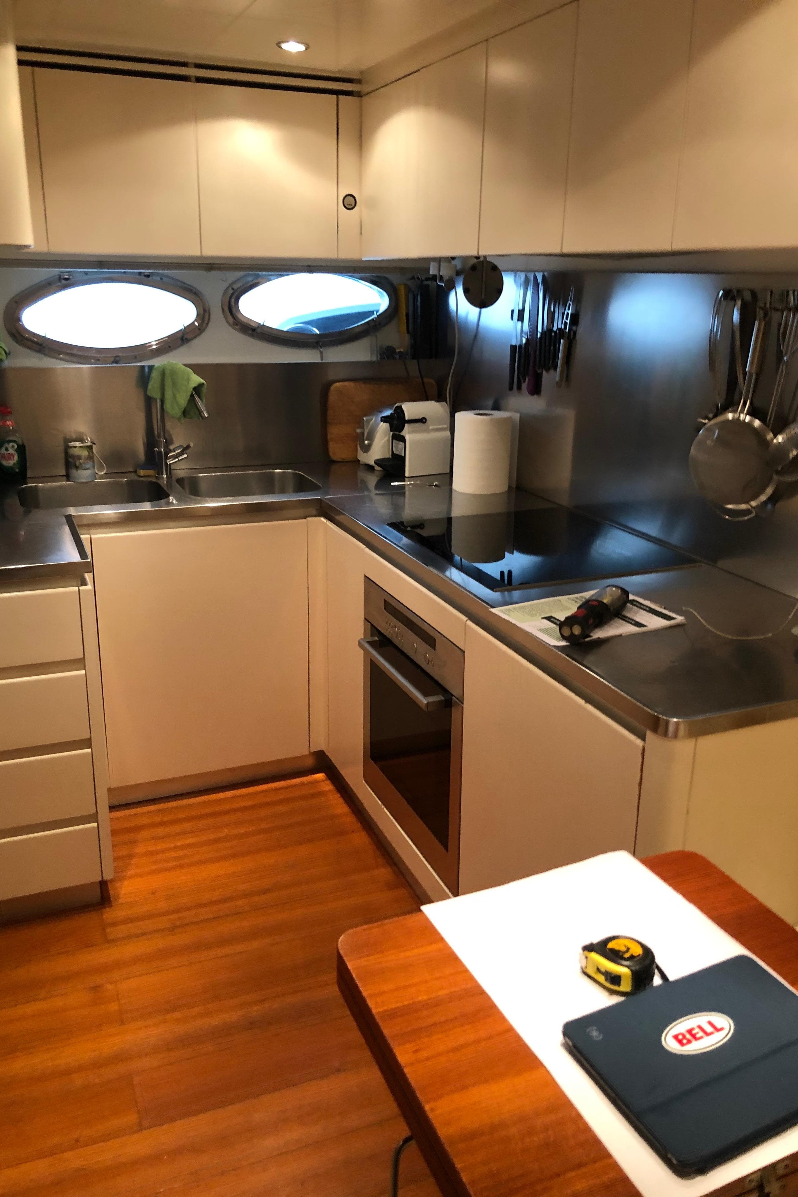 Kitchen interior of a 2008 Pershing 90 yacht with modern appliances and wooden flooring.