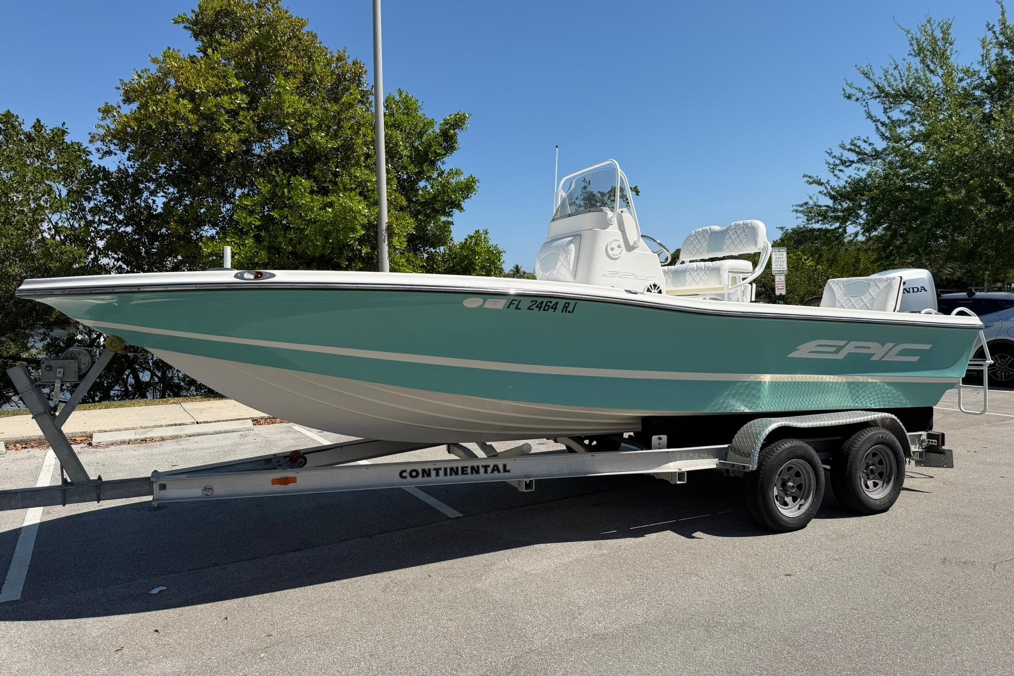 2018 Epic 22SC boat on trailer, parked outdoors under clear blue sky.