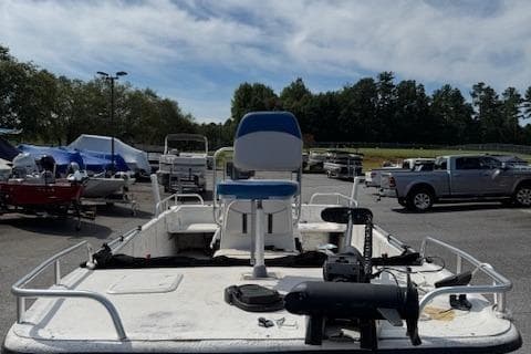 2006 Carolina Skiff 178 DLX boat in parking lot, surrounded by vehicles and trees.