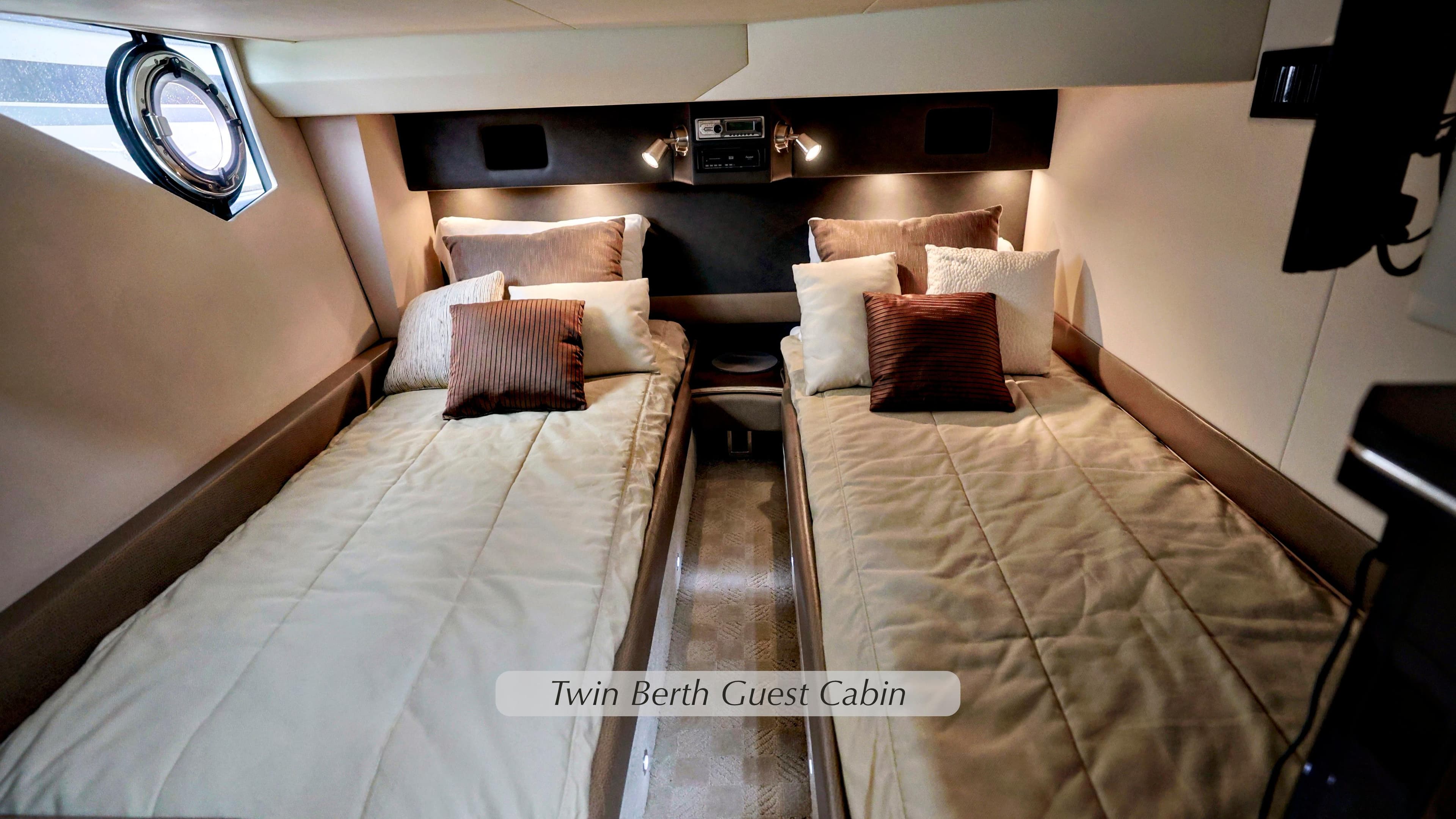 Twin berth guest cabin in 2013 Marquis 500 Sport Bridge yacht, featuring cozy bedding.