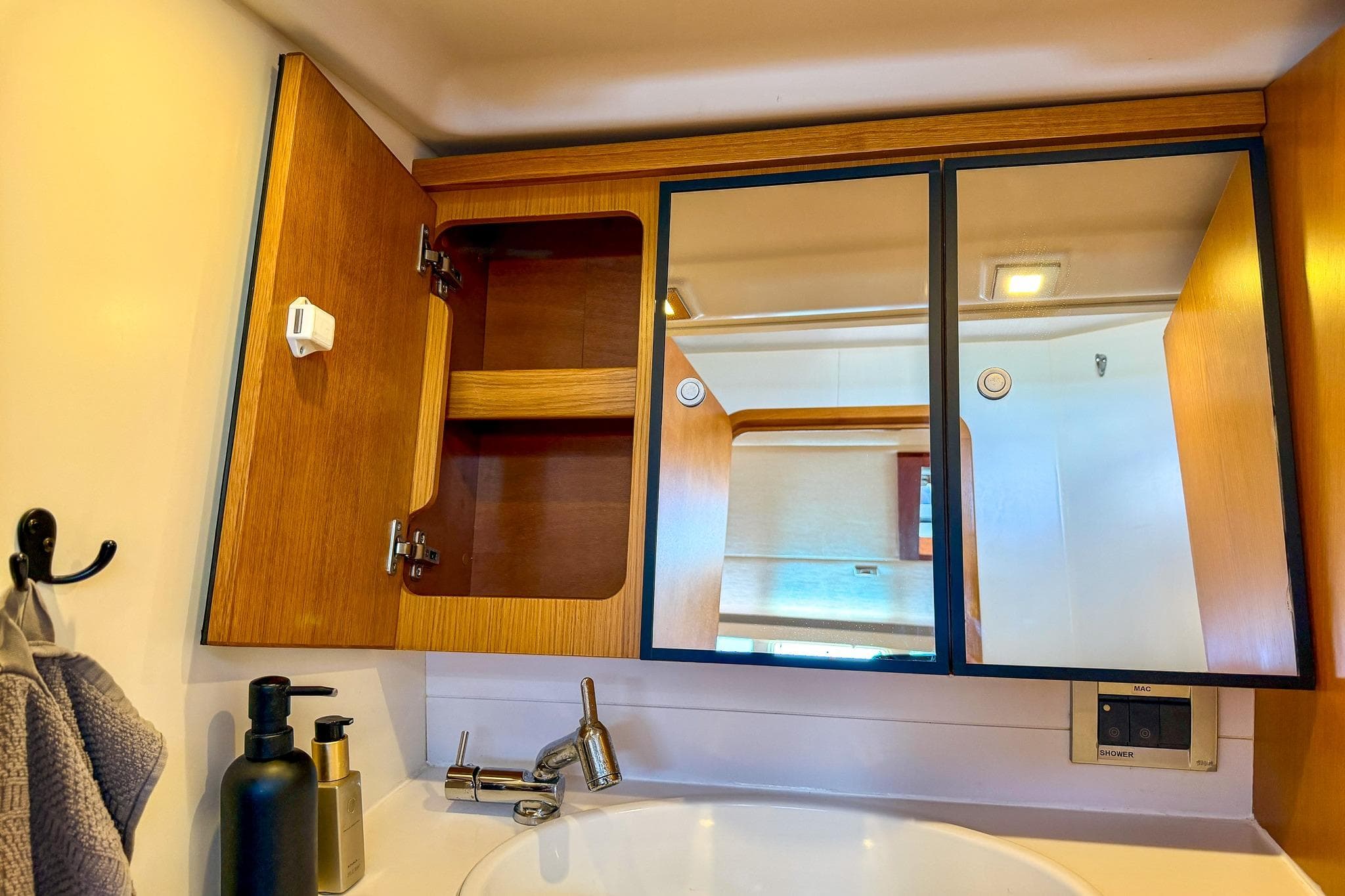 Bathroom vanity with wooden cabinets and mirror in 2010 Grand Soleil 46 yacht.