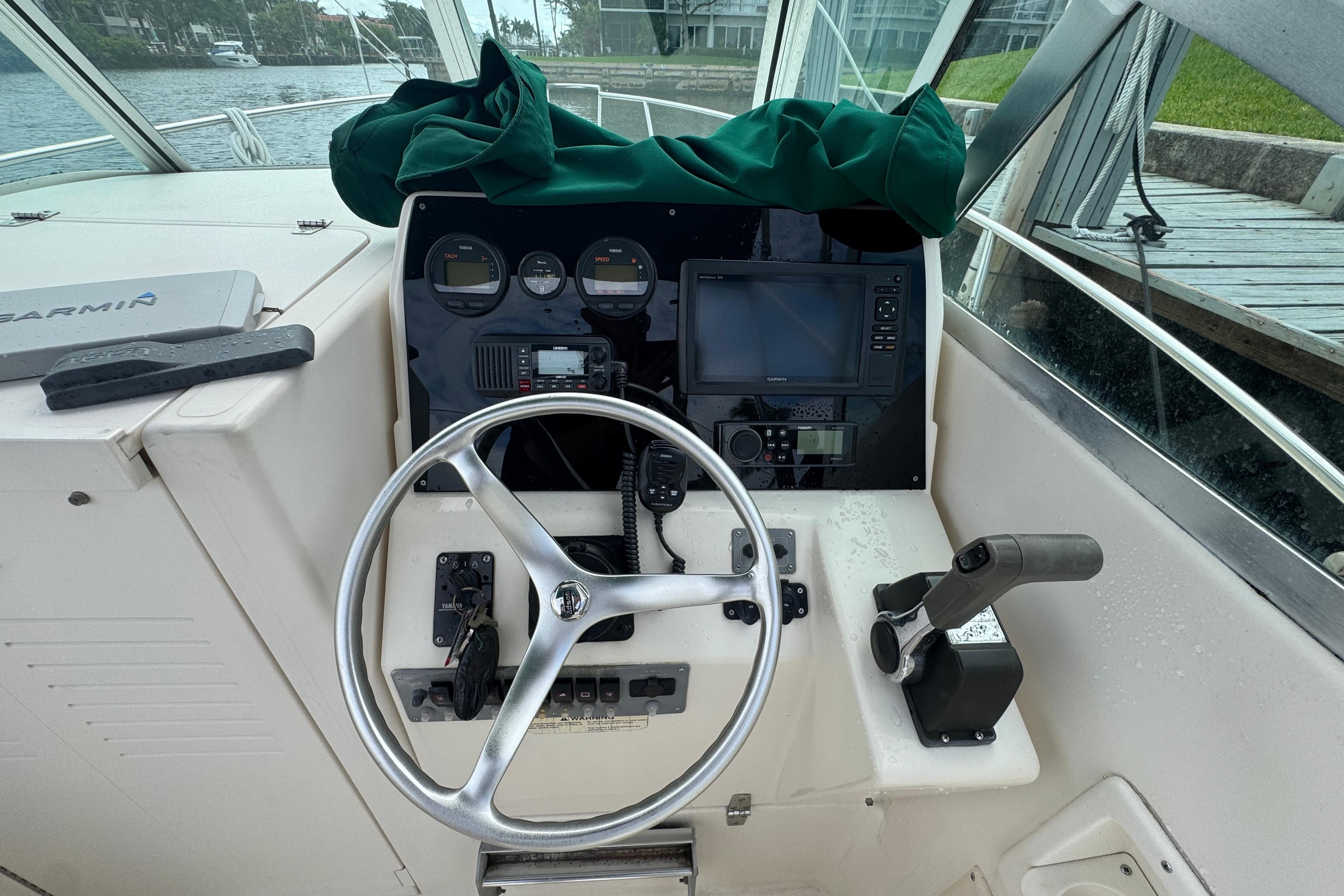 Helm of 2000 Pursuit 2470 Walkaround boat with steering wheel and navigation instruments.