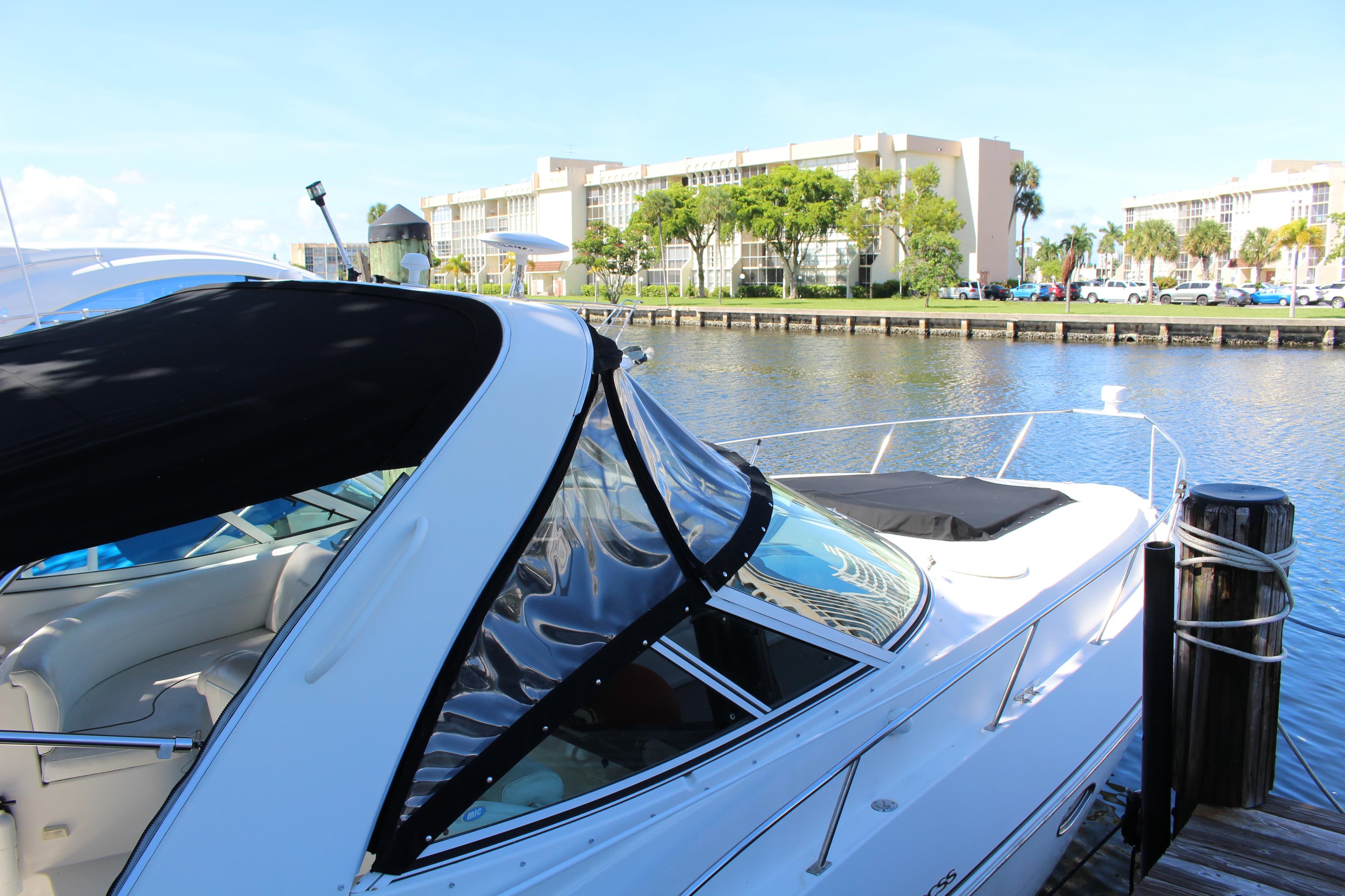 2005 Cruisers Yachts 340 Express docked by waterfront buildings.