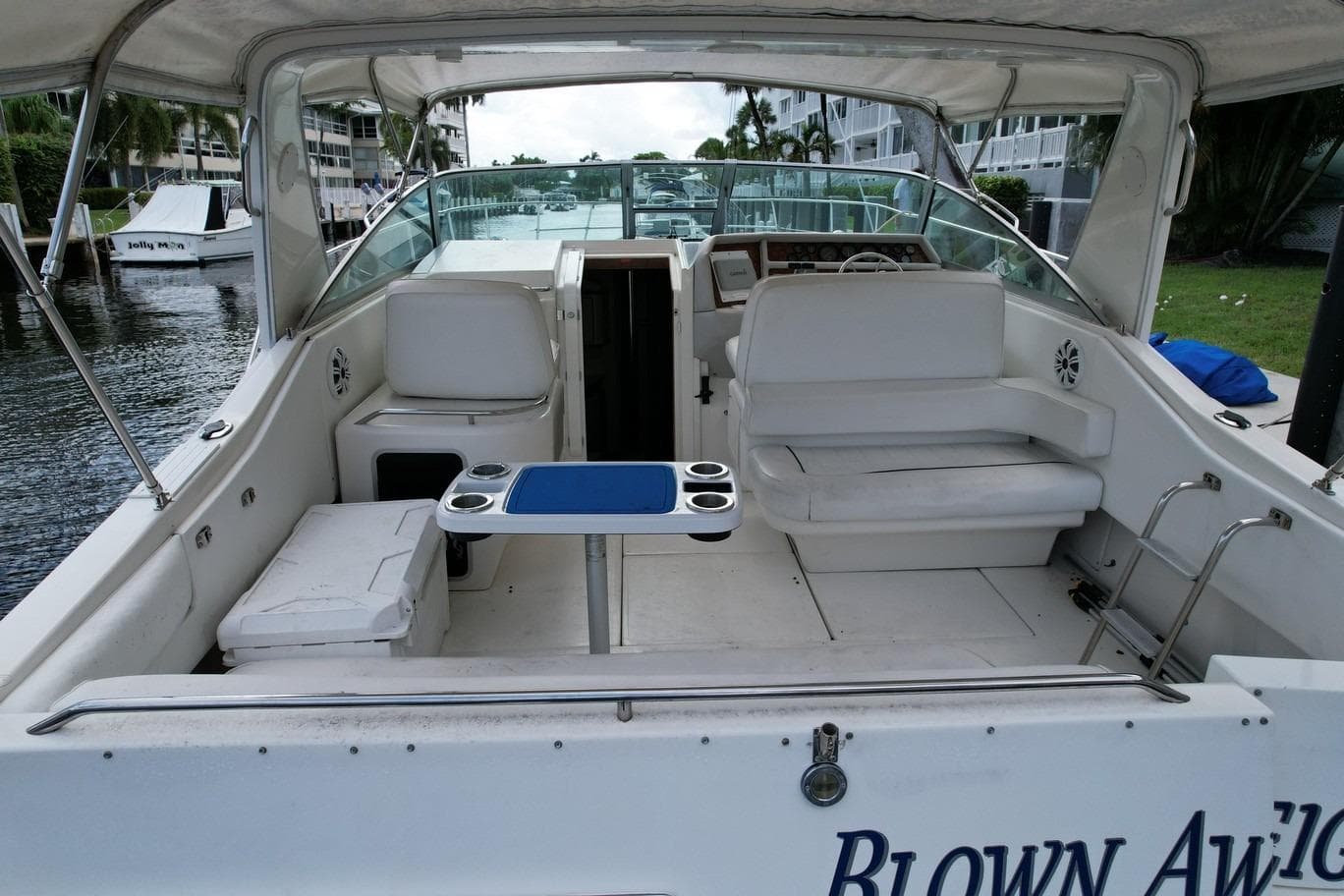 1994 Sea Ray 370 Express Cruiser interior with seating and table, docked by waterfront.