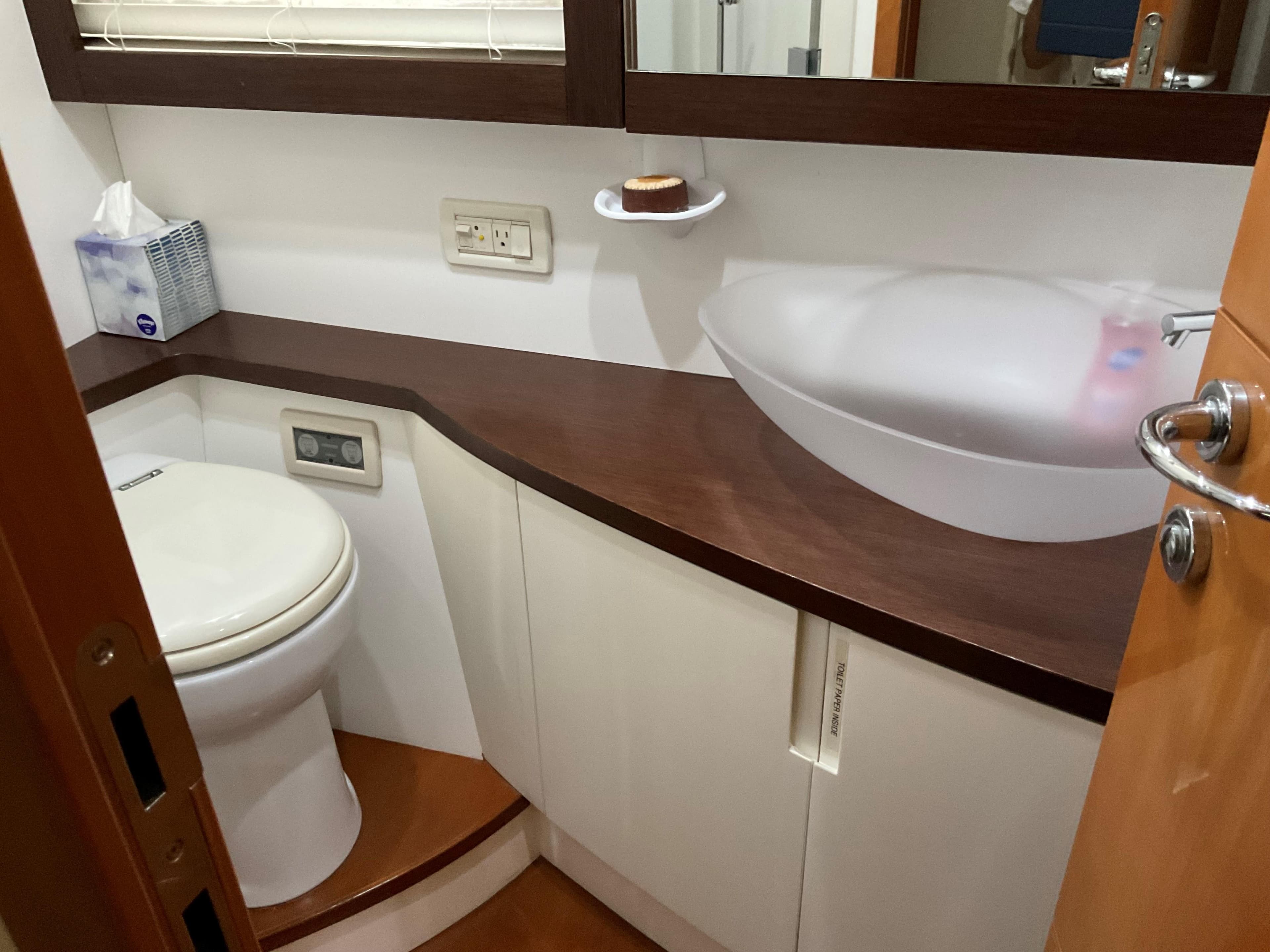 Luxurious bathroom in 2006 Pershing Cruiser with modern sink and toilet.