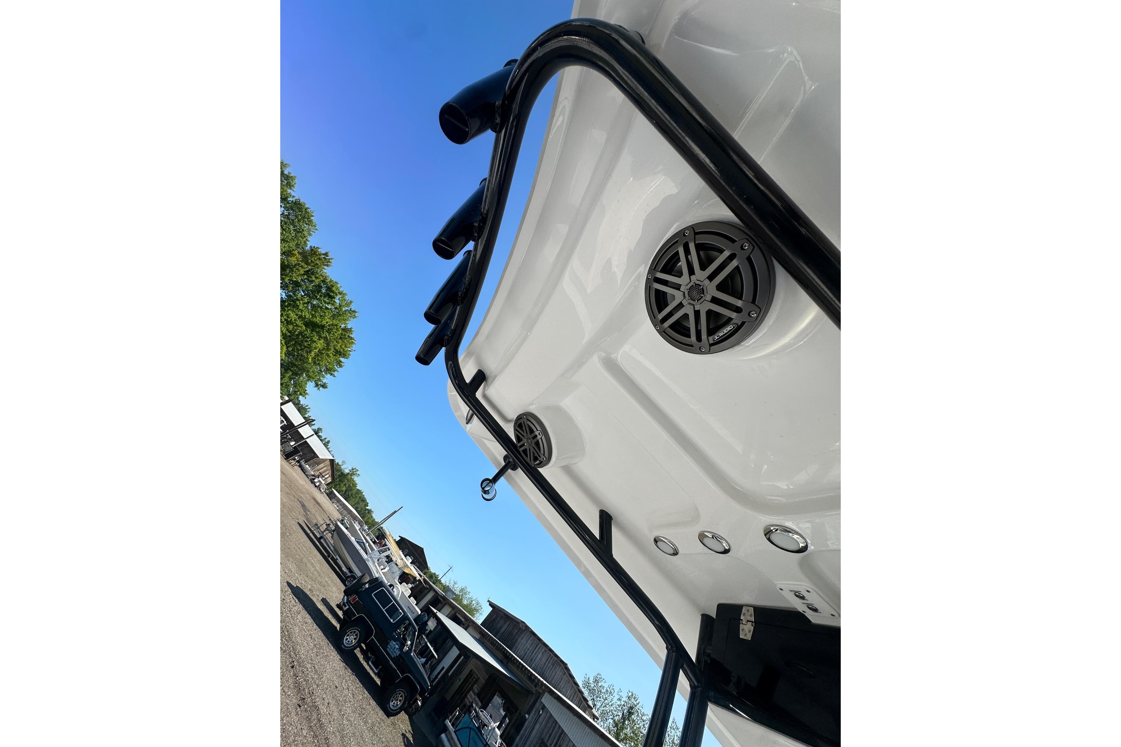 2026 Action Craft 22 Bay boat underside with speaker and railing, clear blue sky background.