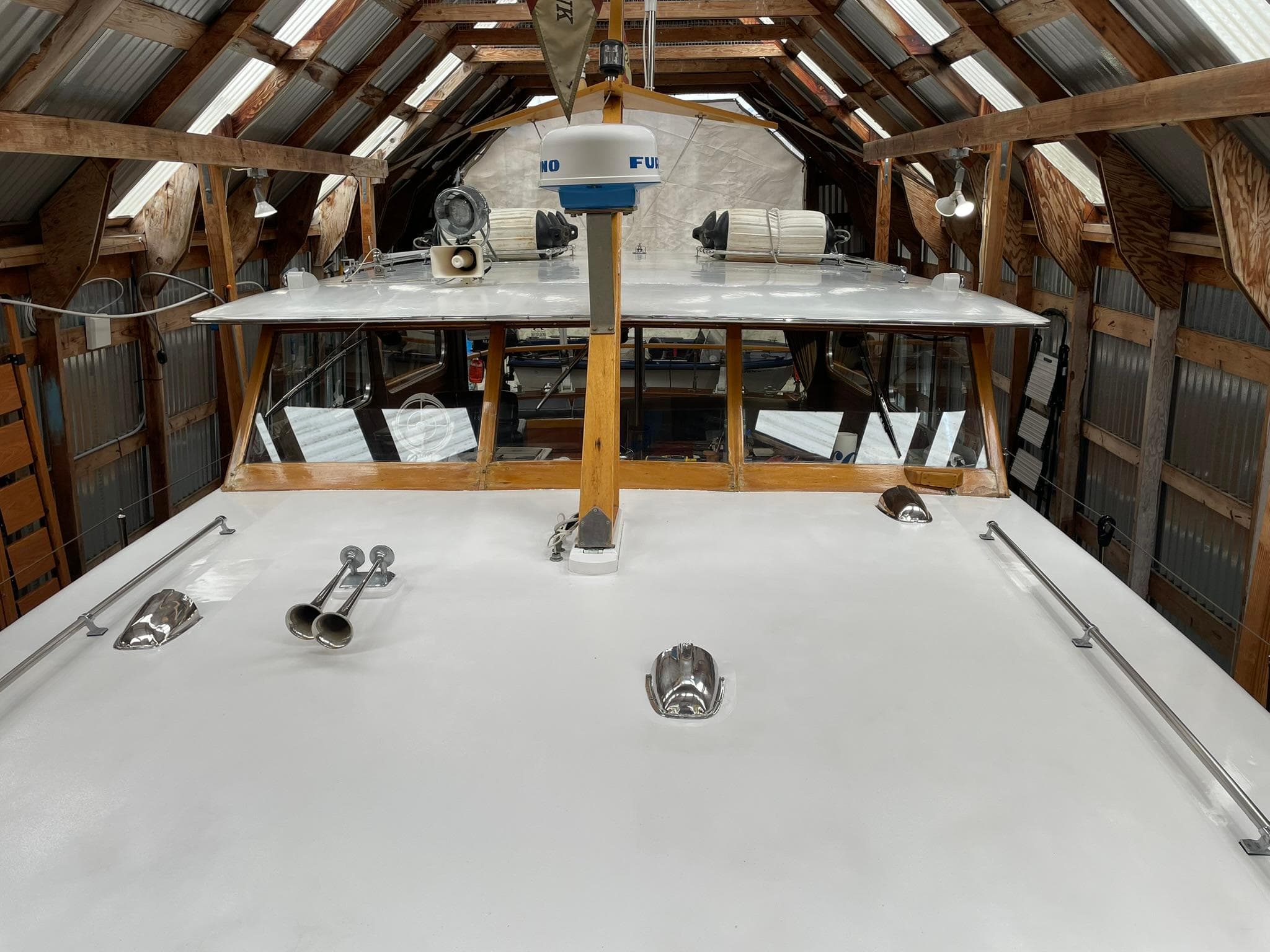 1959 Monk Express Cruiser in a wooden boathouse, showcasing its deck and equipment.