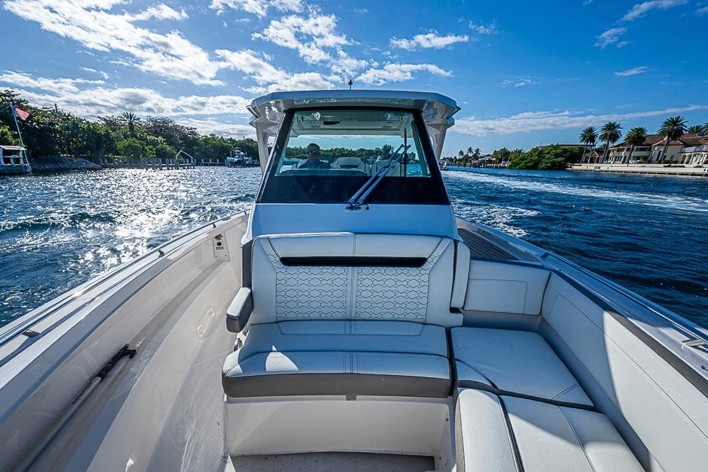2023 Tiara Yachts 34 LS cruising on a sunny day with scenic waterfront views.