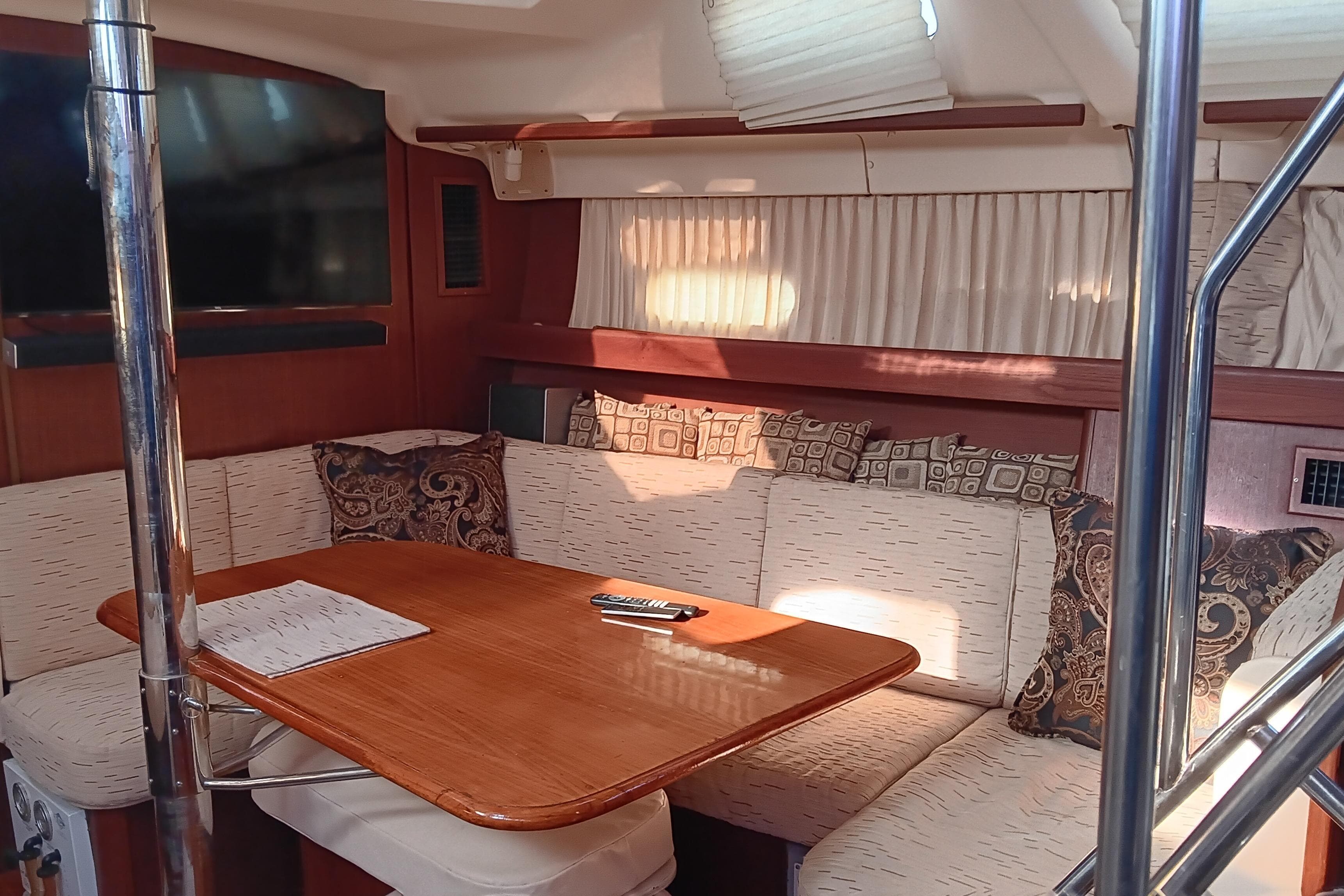 Interior of 1998 Hunter Passage 450 yacht with cozy seating and wooden table.