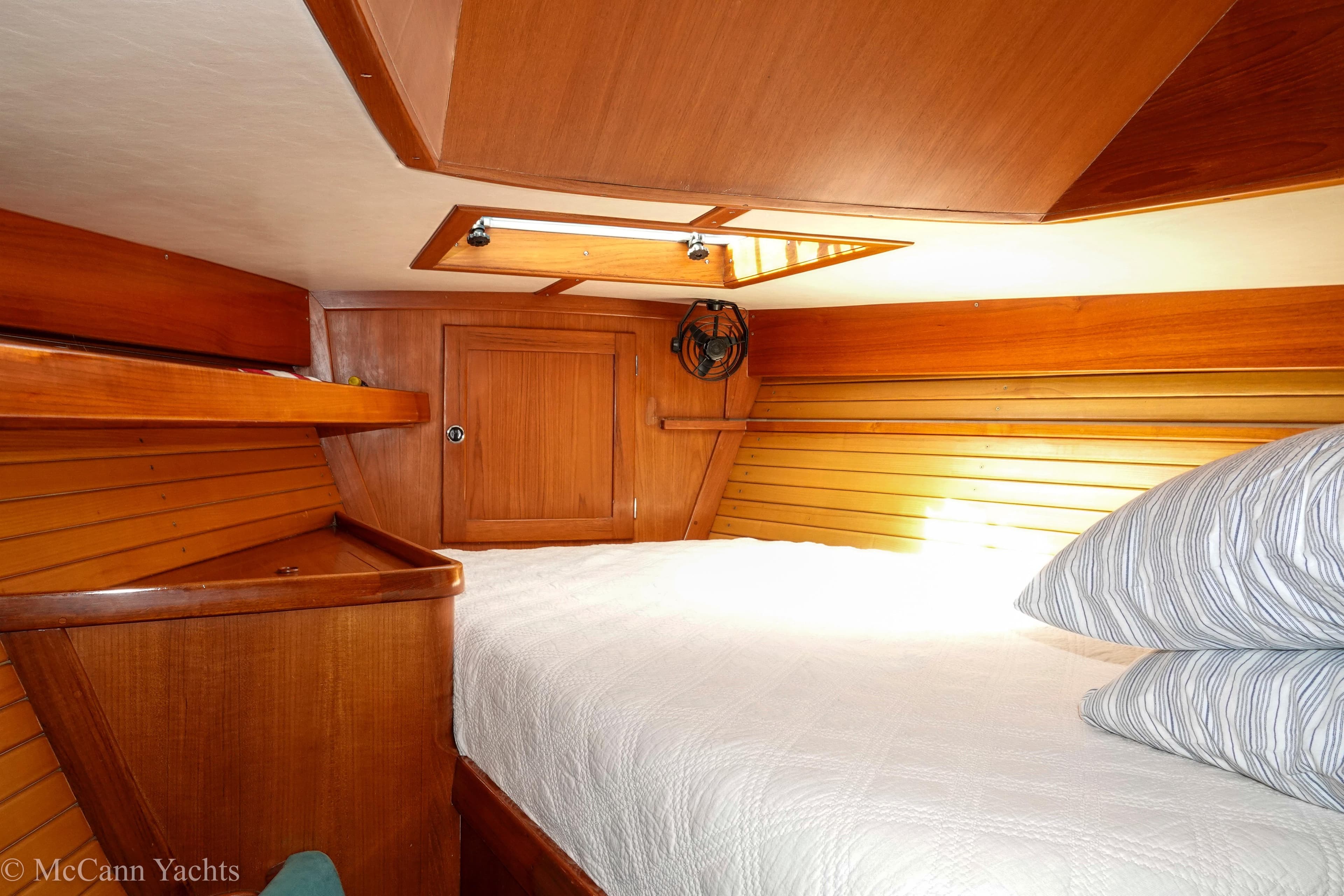 Cozy cabin interior of 1993 Alden 43 Aft Cockpit yacht with wooden paneling and bedding.