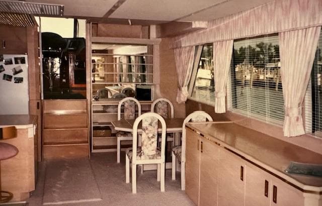 Interior of 1990 Motor Yacht 70 Brata with dining area and large windows.