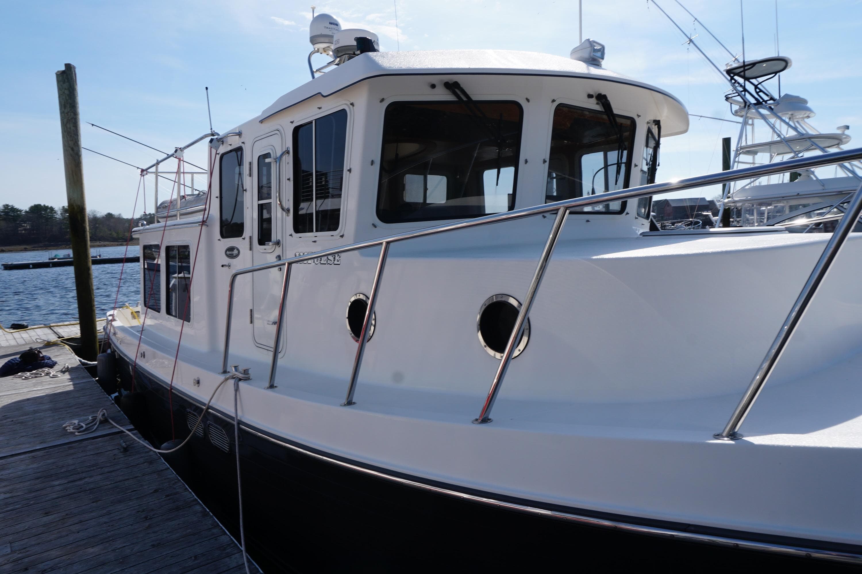 2004 American Tug 34 docked at a marina, showcasing its sturdy design and sleek lines.