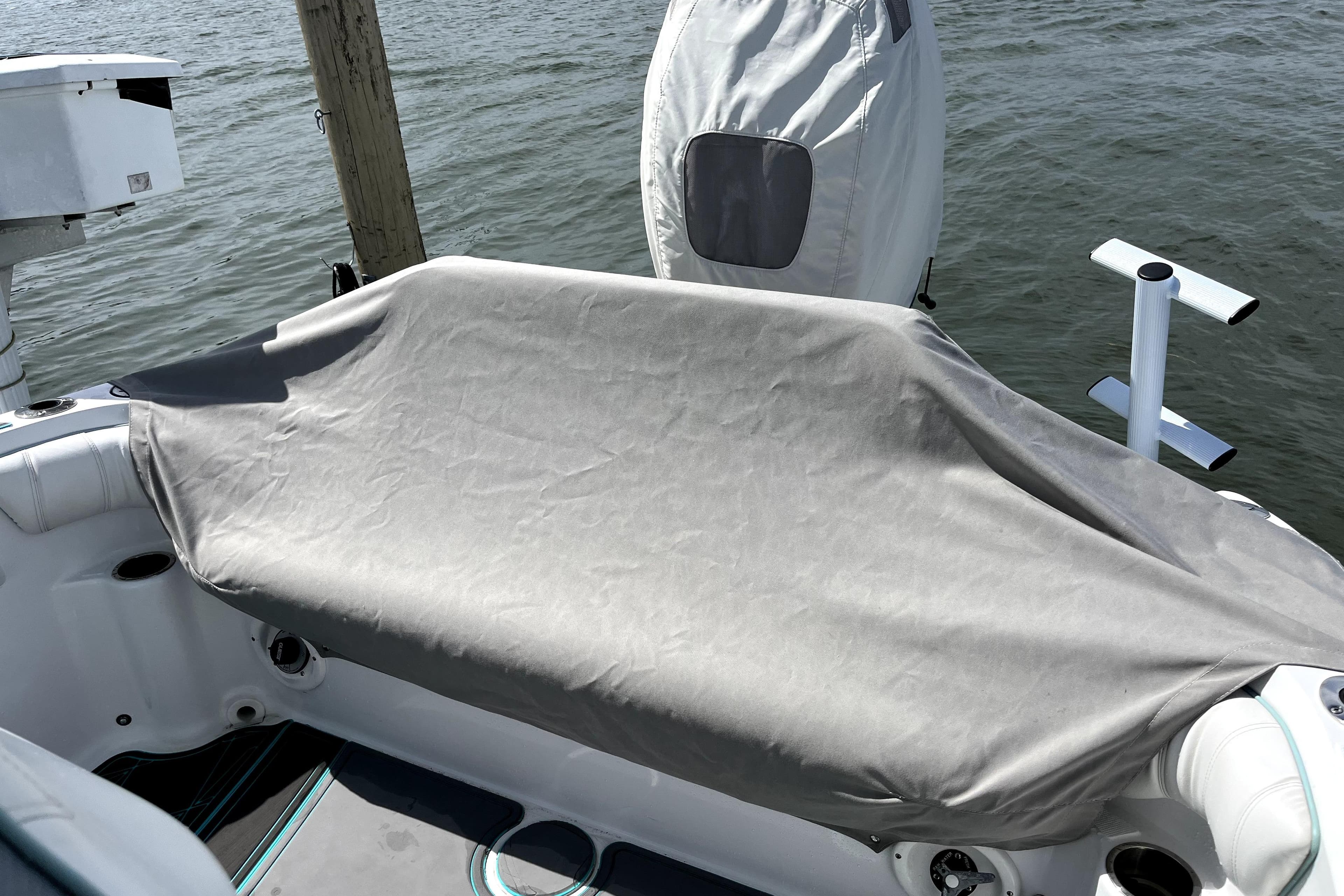 2021 Glasstream 255 Pro-XS boat with covered seating area, docked by the water.