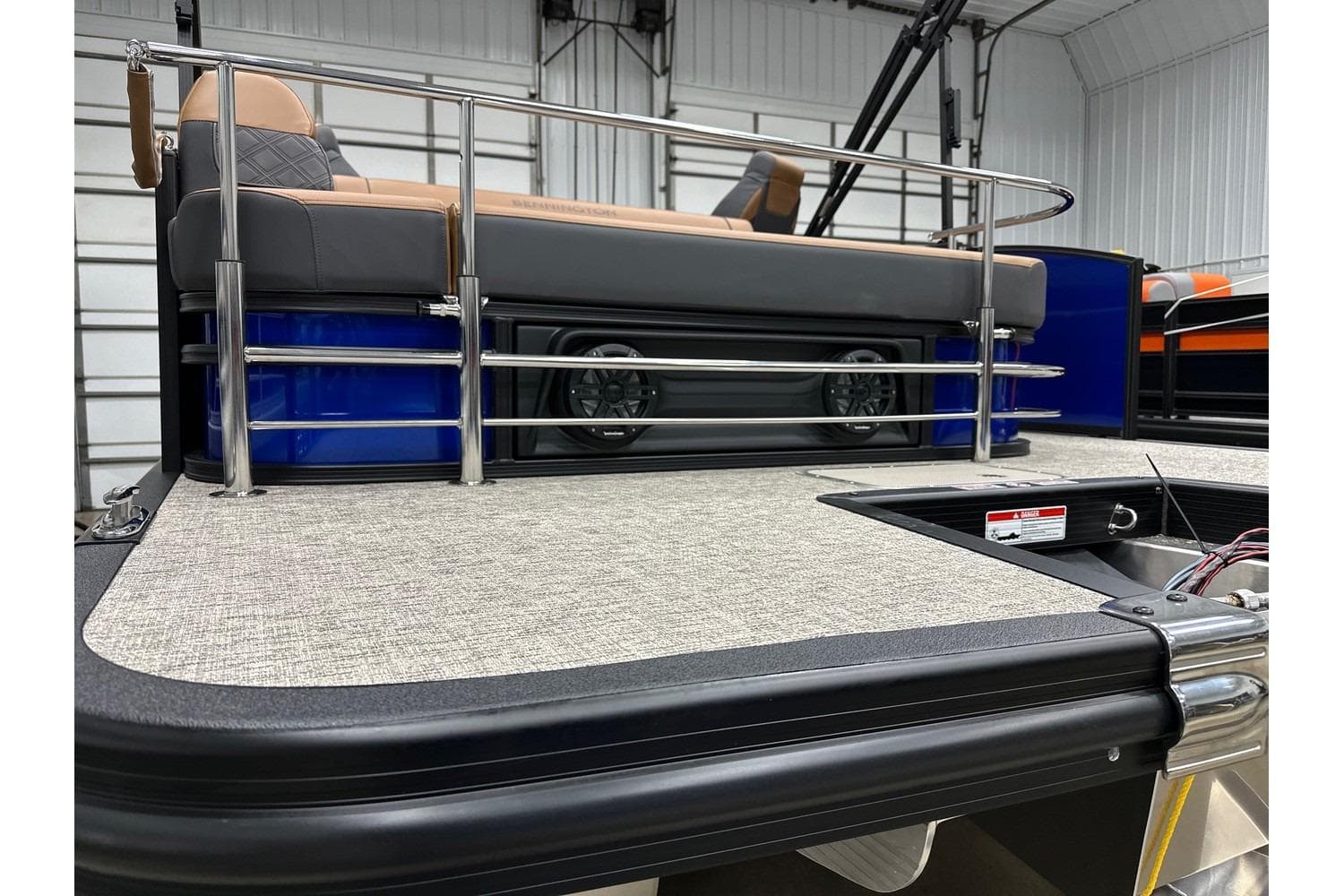 2026 Bennington 22 SSB Swingback boat interior with seating and railing in a showroom.