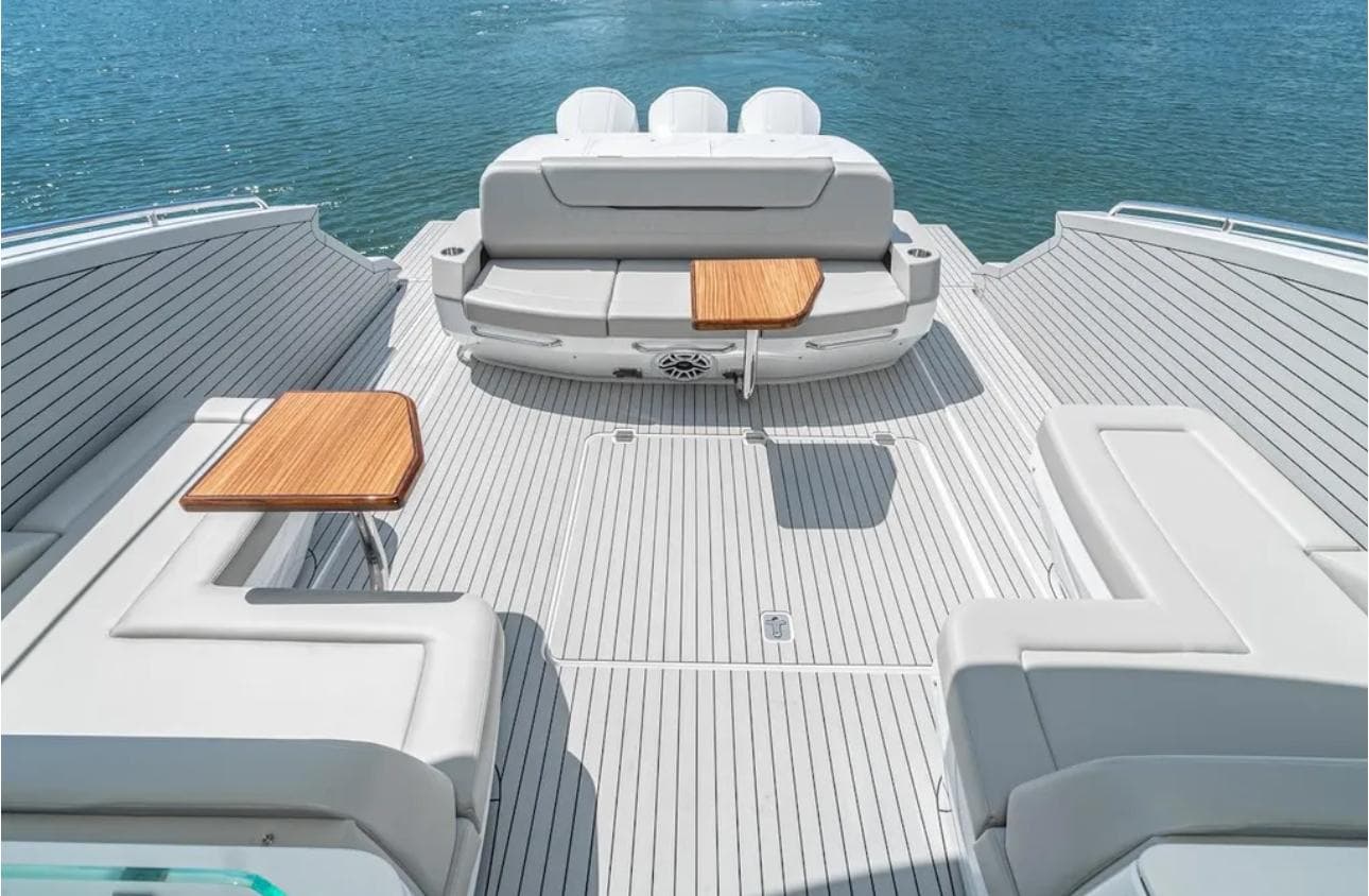 Luxurious 2025 Cruisers Yachts 50 GLS deck with seating and tables on open water.