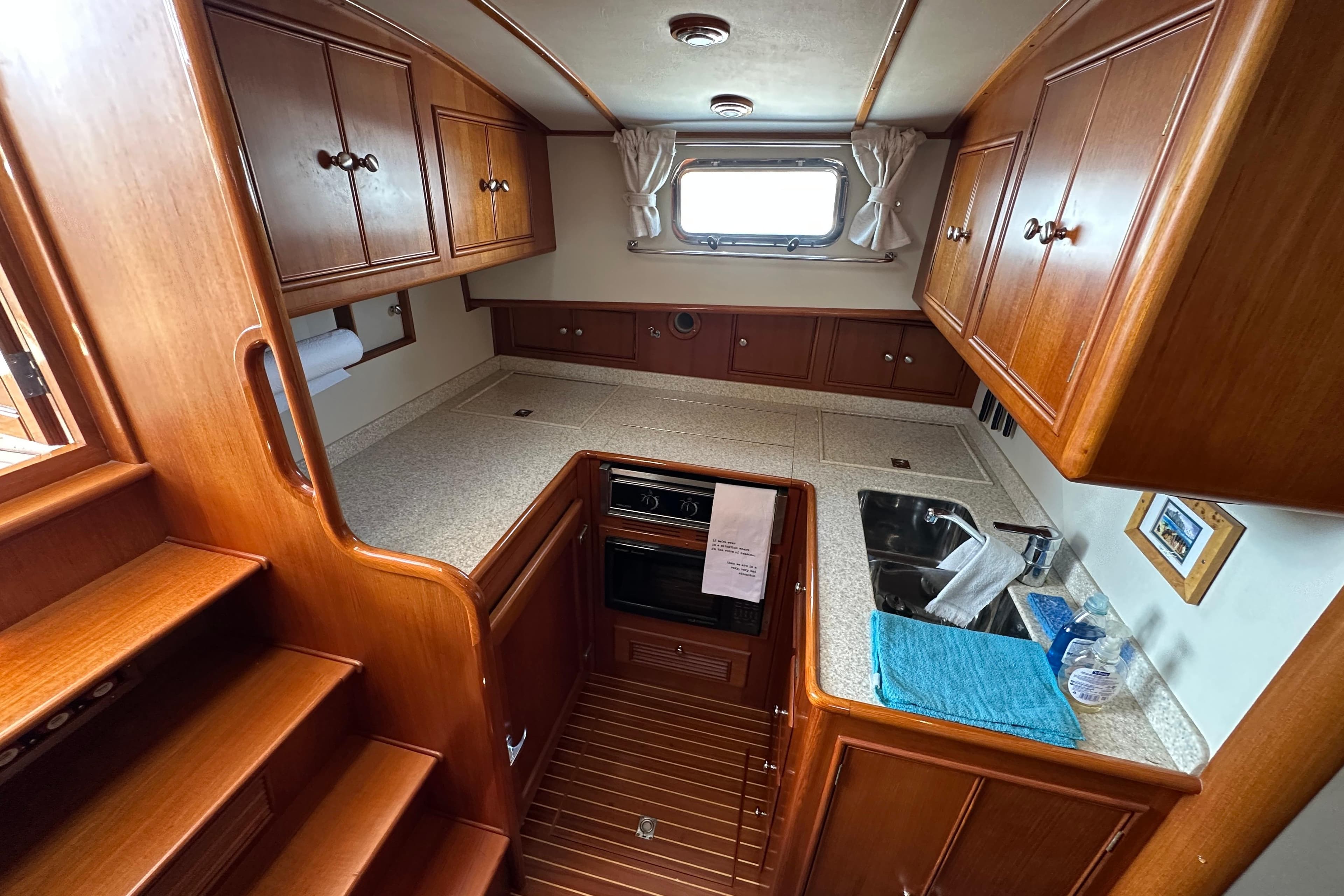 2003 Grand Banks 43 Eastbay HX yacht kitchen with wooden cabinets and compact appliances.