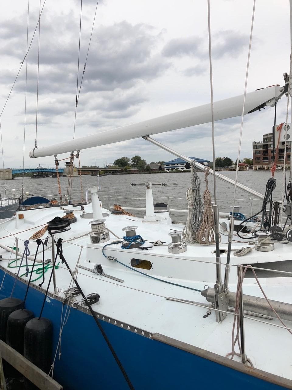 1973 Mull 54 sailboat docked at a marina with cloudy sky.