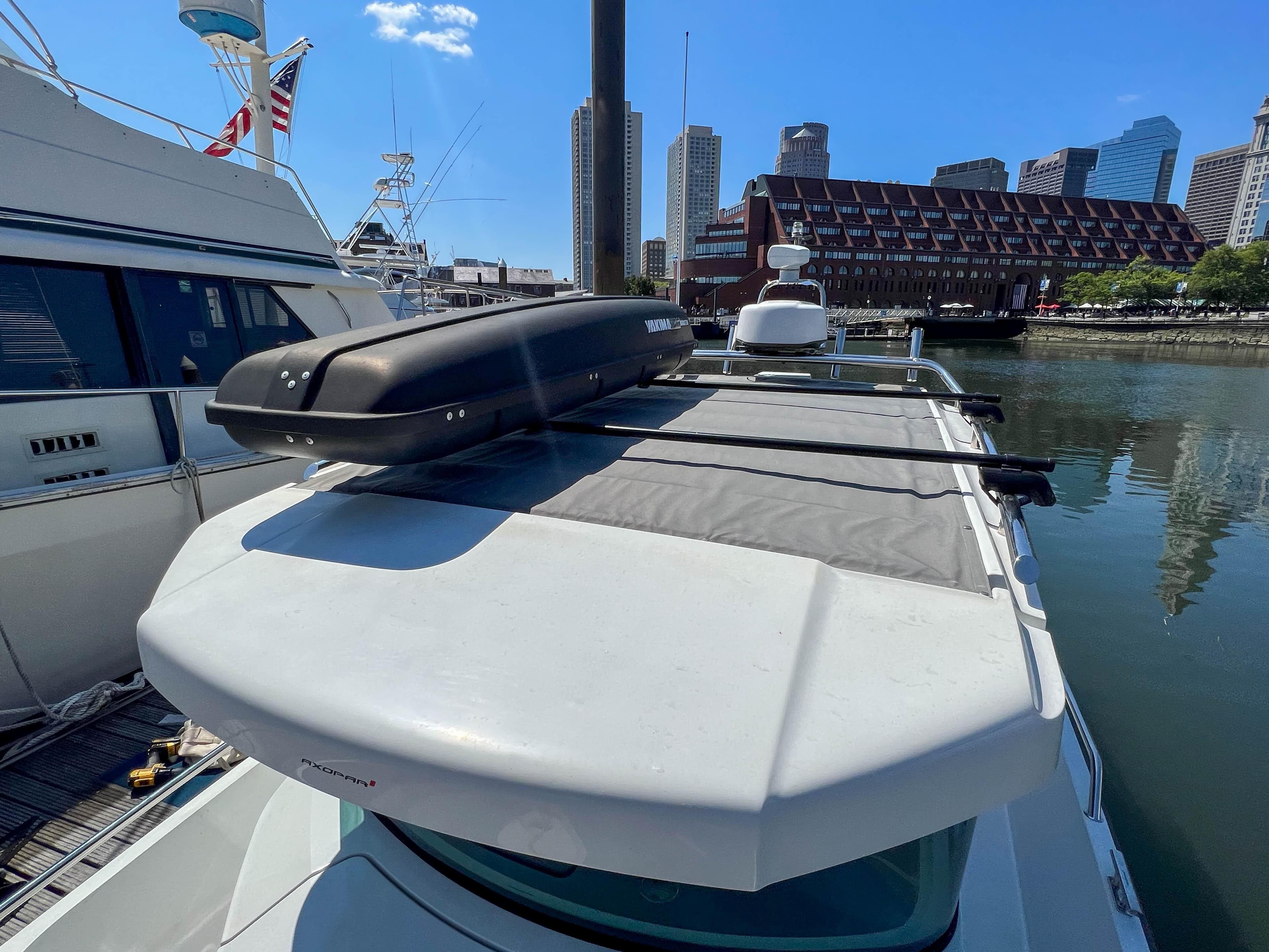 Axopar 28 Cabin 2020 docked in a harbor with city skyline.