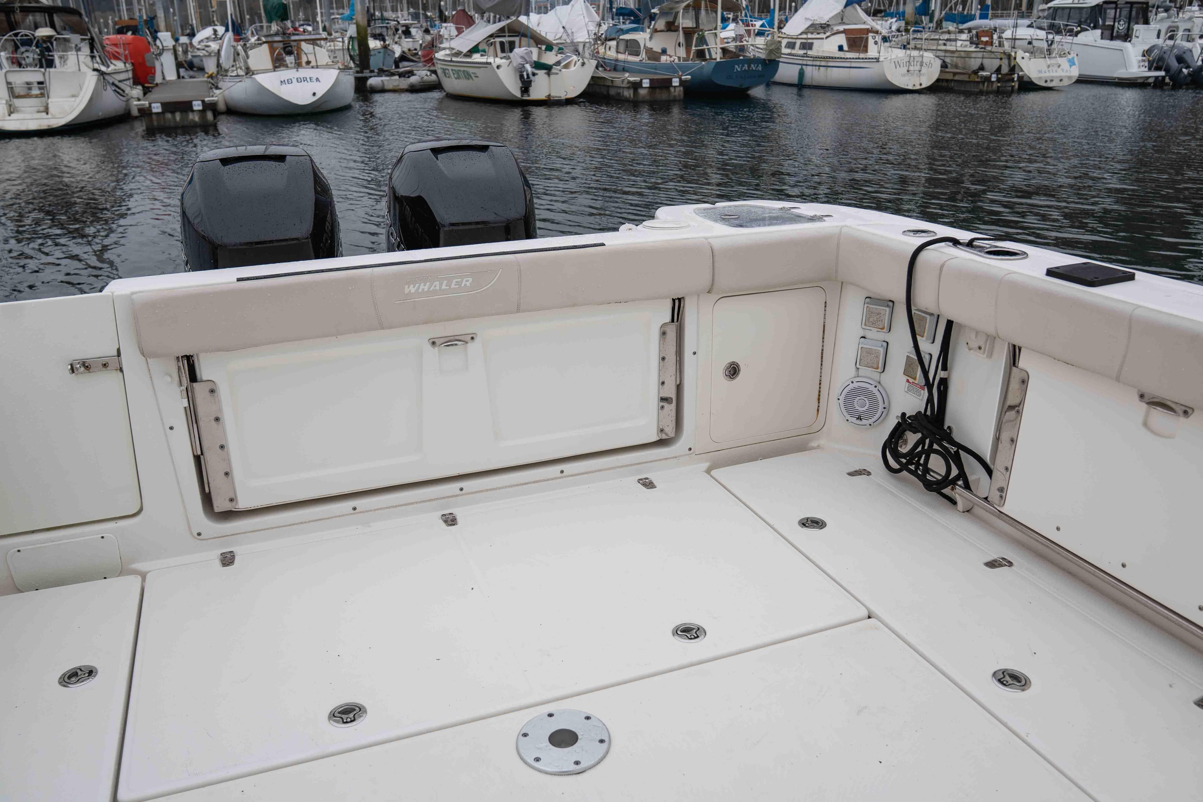 2015 Boston Whaler 315 Conquest Pilothouse boat deck with dual engines in marina.