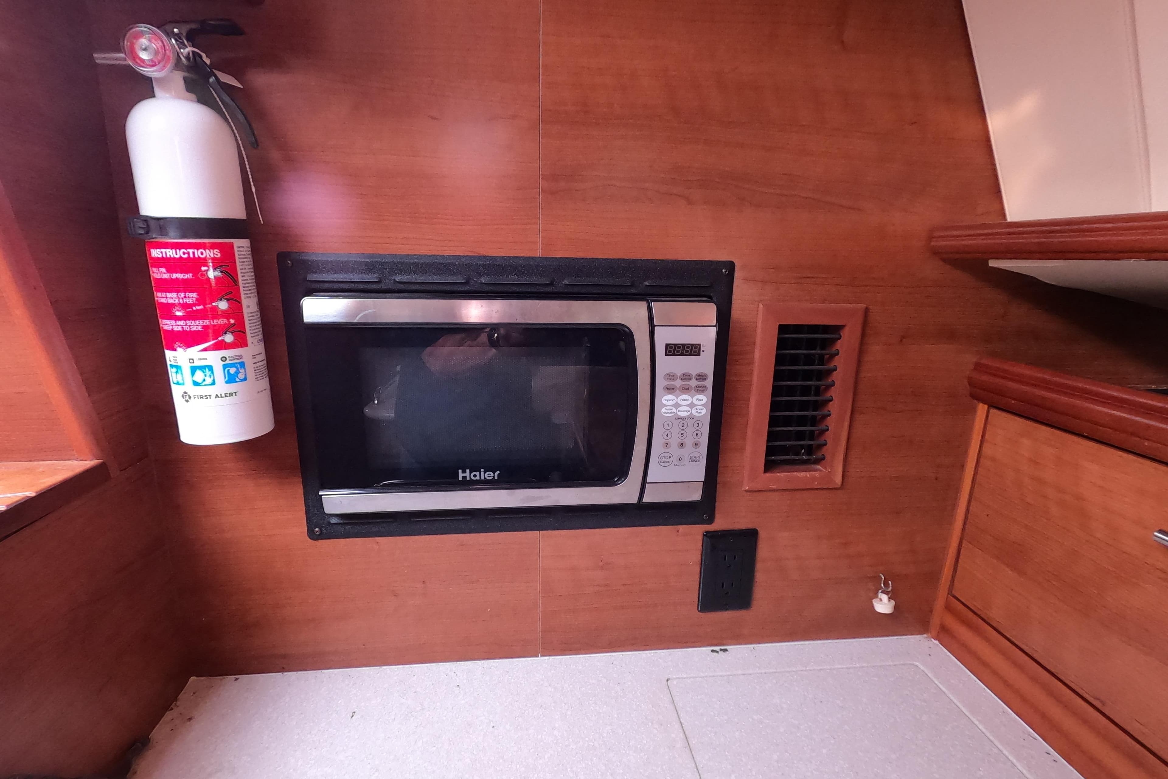 Fire extinguisher and microwave in 2013 Marlow-Hunter e33 yacht interior kitchen.