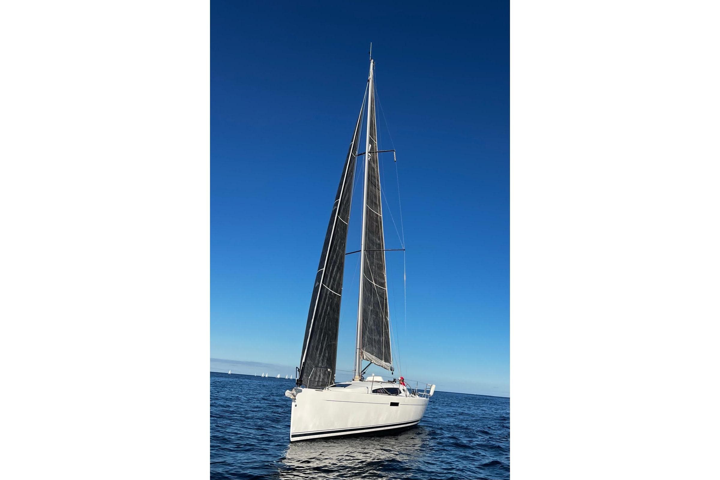 2018 J-Composites J/112E sailboat on open water under clear blue sky.