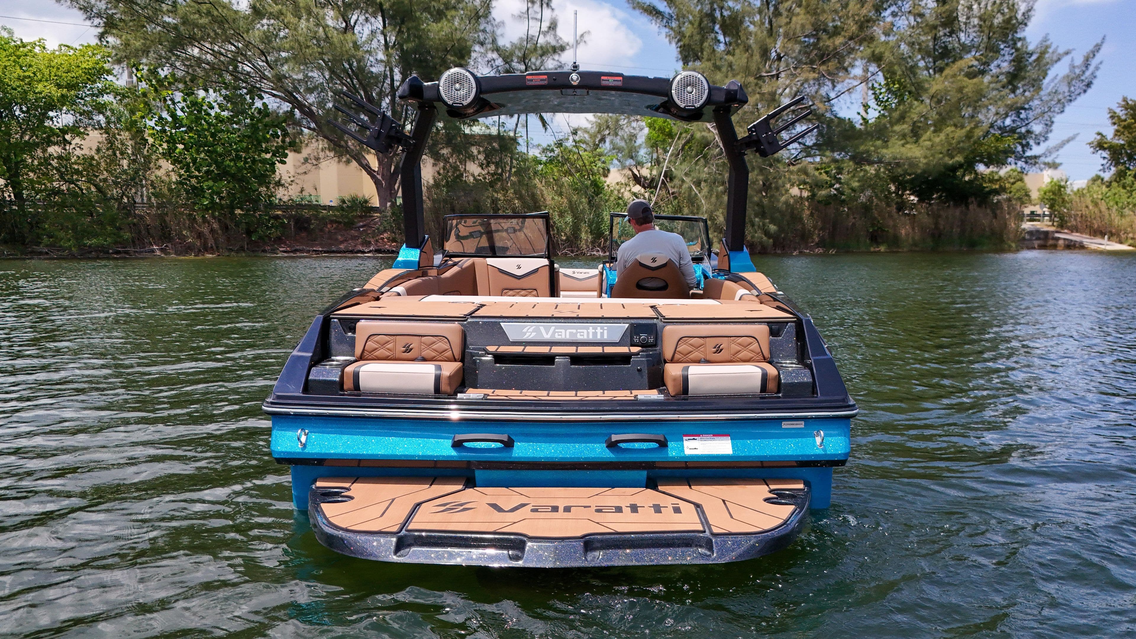2024 Varatti Z2373 boat on a lake, rear view with lush greenery.
