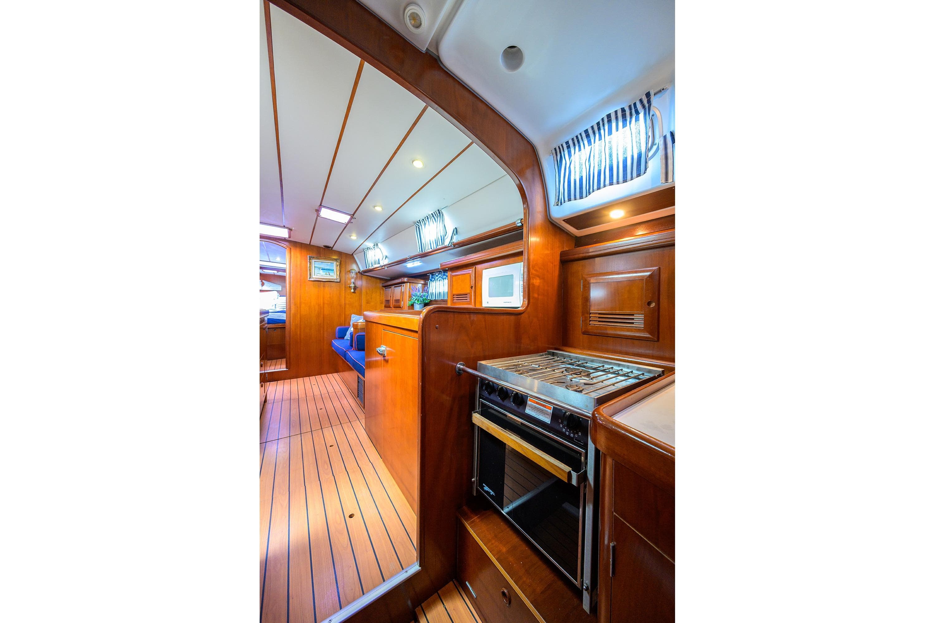 Interior of 2003 Beneteau 50 yacht with wooden finish and modern kitchen amenities.