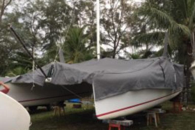 2016 Prescott Firefly 850 catamaran covered, surrounded by trees.