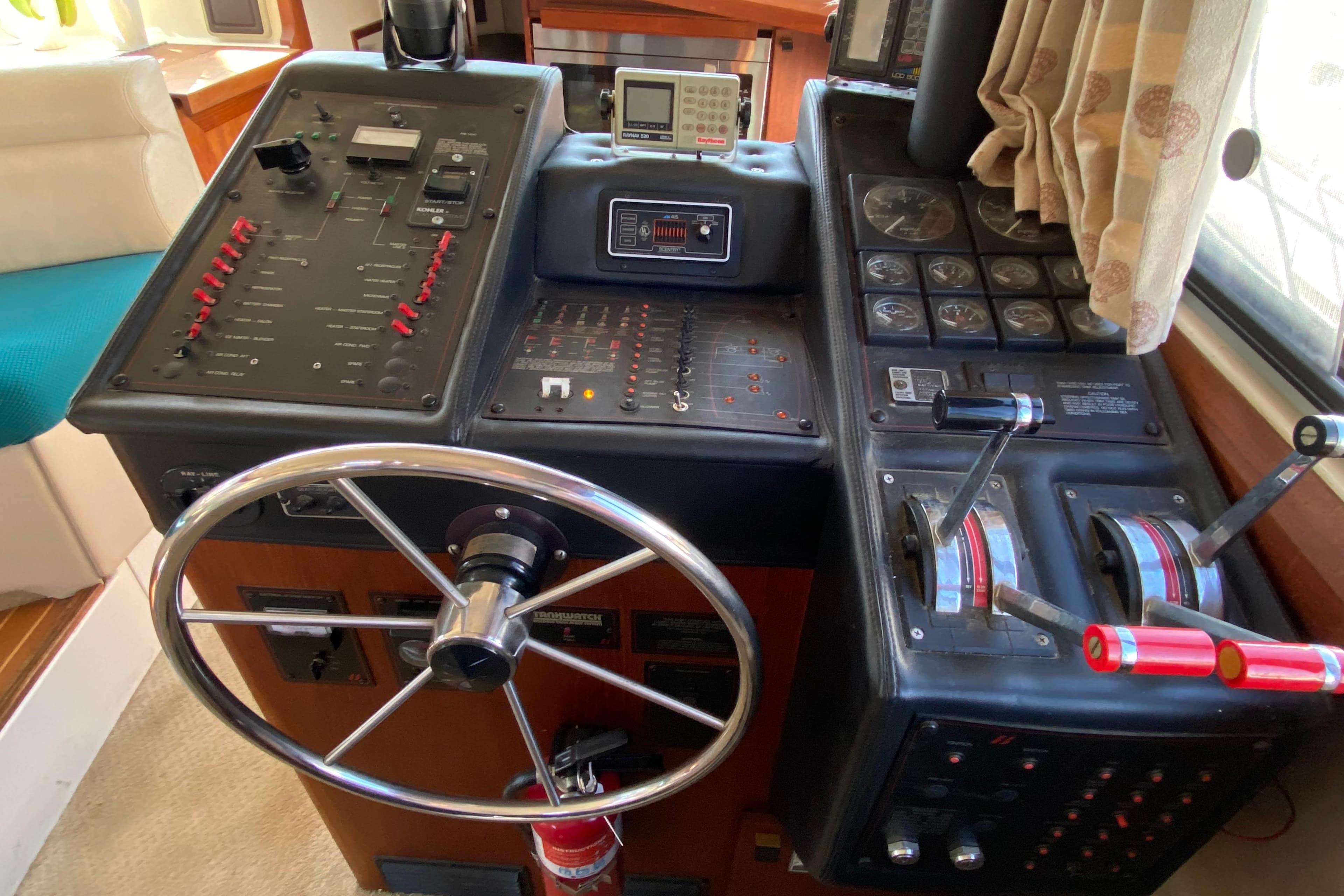 1989 Bayliner 3888 Motoryacht helm with steering wheel, control panels, and throttle levers.