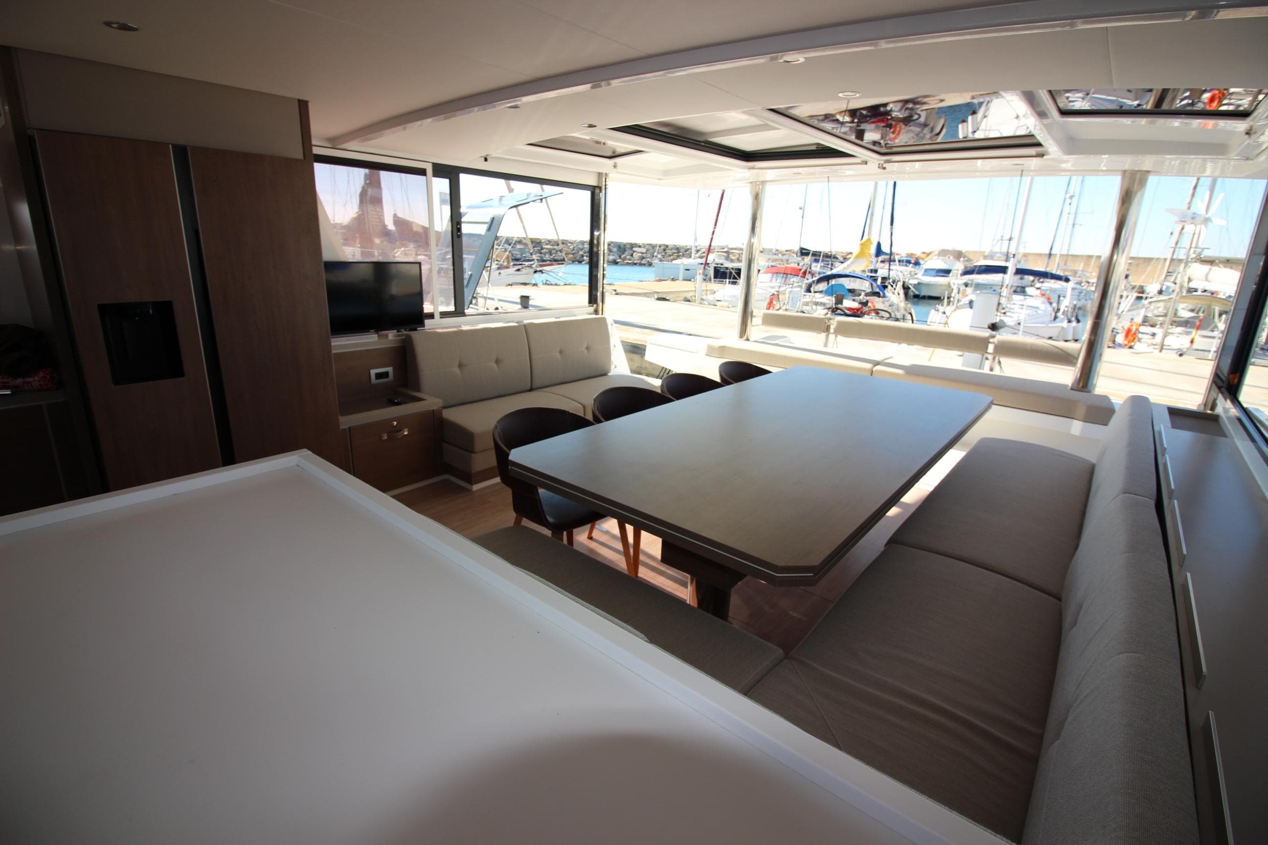 Luxurious interior of 2022 Bali 5.4 catamaran with spacious seating and marina view.
