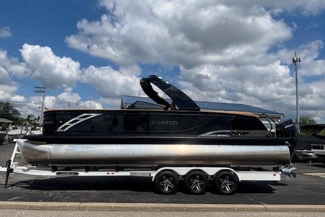 2025 Godfrey San Pan SP2700SBW pontoon boat on trailer under cloudy sky.