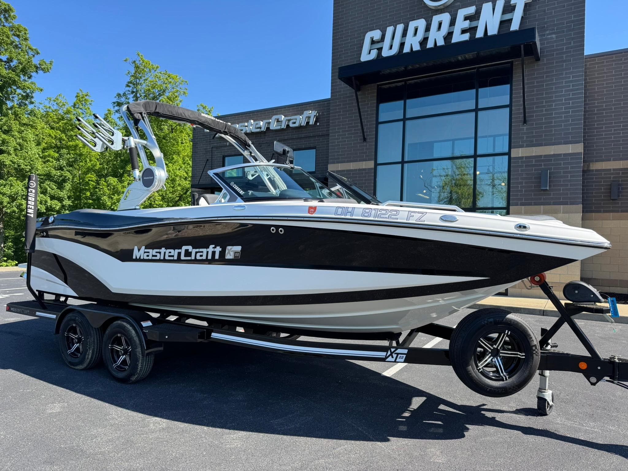 2020 MasterCraft XT22 boat on trailer outside dealership, showcasing sleek design and modern features.