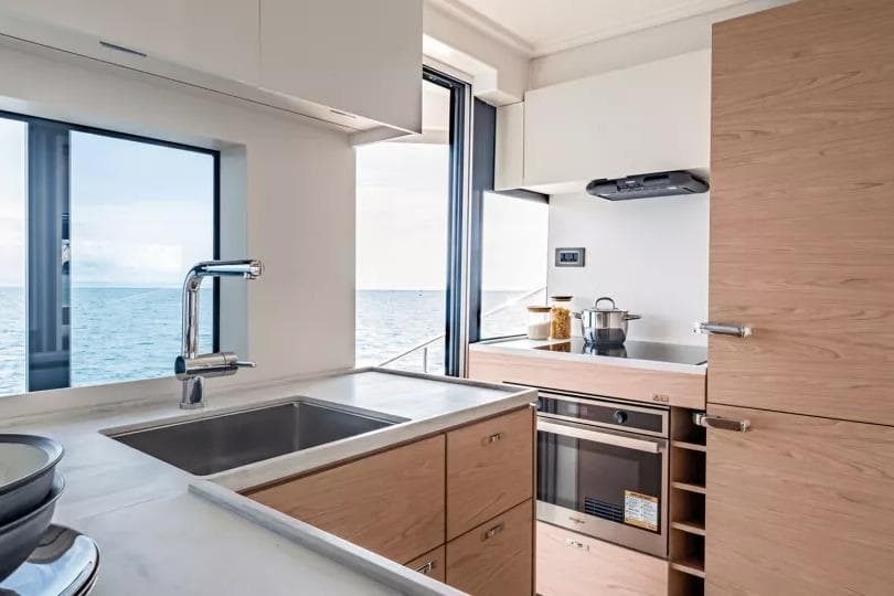 Modern kitchen interior on 2026 Beneteau Grand Trawler 62 yacht with ocean view.